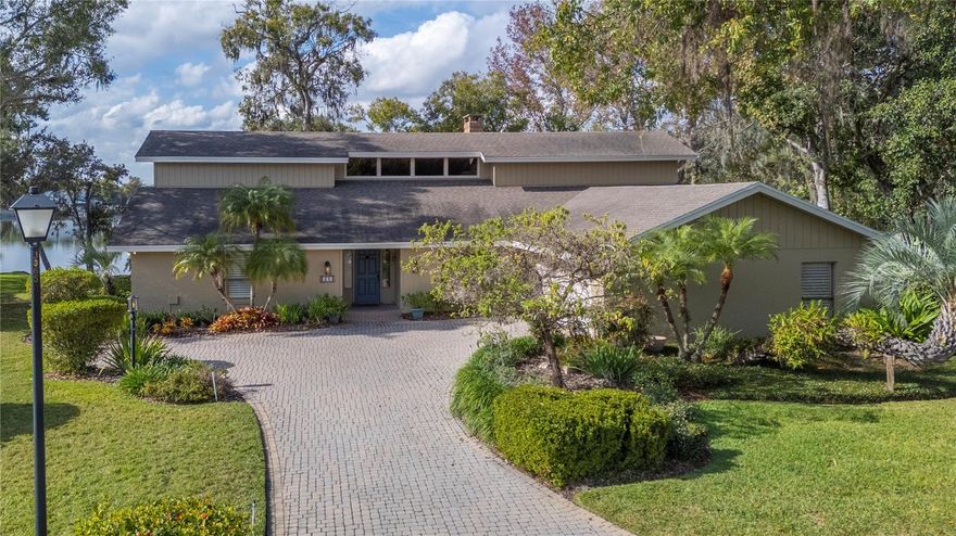 Special waterfront offering in The Woods of Christina! This custom built 3 bed 3 bath one owner home offers so much - 250 feet of lakefront with multilevel dock, cul de sac location, whole house generator (2024), updated kitchen and baths, ceramic tile in main areas, Plantation shutters, over 800 sq ft of porches, oversized garage, paver driveway/extra parking and the list goes on! As you enter the house the spacious living room with soaring ceilings, fireplace wall with builtins and lake views is a showstopper! Wood look tile on the floor and tongue and groove ceiling add to the appeal. The formal dining room is spacious plus there is a breakfast nook (built in seating) with expansive lake views. The kitchen has been remodeled with newer cabinetry (lots of pullouts!), counters and appliances The primary suite is oversized and has its own private screened porch. The ensuite bath has dual vanities and updated cabinetry. Two bedrooms are on the opposite side of the house plus 2 baths - one is connected to both bedrooms as well as the main porch. The main screened porch with paver flooring offers expansive lake views and can be accessed from the living room and 3rd bedroom. A summer kitchen makes outdoor entertaining a breeze!  Down by the lake is a deck with built in seating and down a few steps is a dock which is great for fishing! Special lighting has been added. This is one you do not want to miss!!!