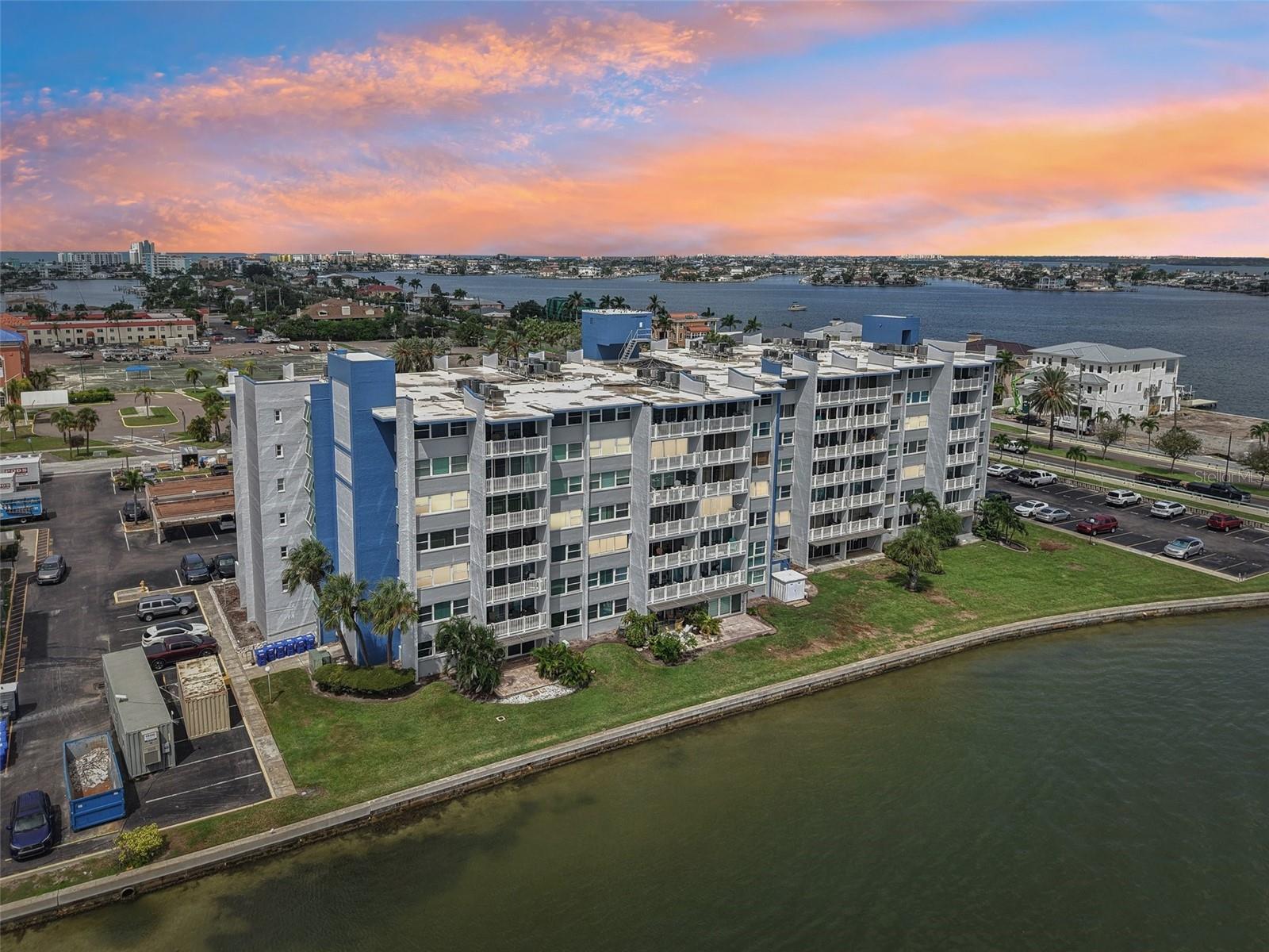Welcome home to your waterfront corner Penthouse! This top-floor residence at Treasure Island Tennis & Yacht Club is a move-in-ready mostly furnished condominium offering breathtaking water and skyline scenery from every room, including downtown St. Petersburg in the distance. From morning sunrises to dolphin sightings and yachts gliding through the channel, the views here are second to none. Inside, the home has been remodeled to an open layout that connects the kitchen, dining area, and great room—perfect for both relaxing and entertaining. The split-bedroom plan ensures privacy, giving guests their own retreat. Details such as wide-plank hardwood floors, natural stone baths, and custom finishes throughout reflect a thoughtful, high-quality renovation. The kitchen is a true showpiece with Cambria quartz counters, stainless steel appliances, soft-close cabinetry, tray ceiling, and designer fixtures. The primary suite offers a spa-like bath with dual vanities, quartz surfaces, and a frameless glass walk-in shower. The guest suite is equally impressive, featuring a deep soaking tub. Additional highlights include hurricane-rated windows and sliders, motorized shades, modern shaker-style doors, updated baseboards, abundant closet space, and added windows that flood the condo with natural light. Practical perks include in-unit laundry (washer/dryer included), same-floor storage, and one assigned parking space, 711, with plenty of guest parking. The building itself has a brand-new elevator, stylish lobby renovation, and is pet-friendly. Treasure Island’s sandy beaches and Sunset Beach are minutes away by bike, golf cart, or a short stroll. Downtown St. Petersburg’s restaurants, galleries, and festivals are just across the bridge. Move in before the annual Lighted Boat Parade sails past your windows and enjoy waterfront living at its very best.
