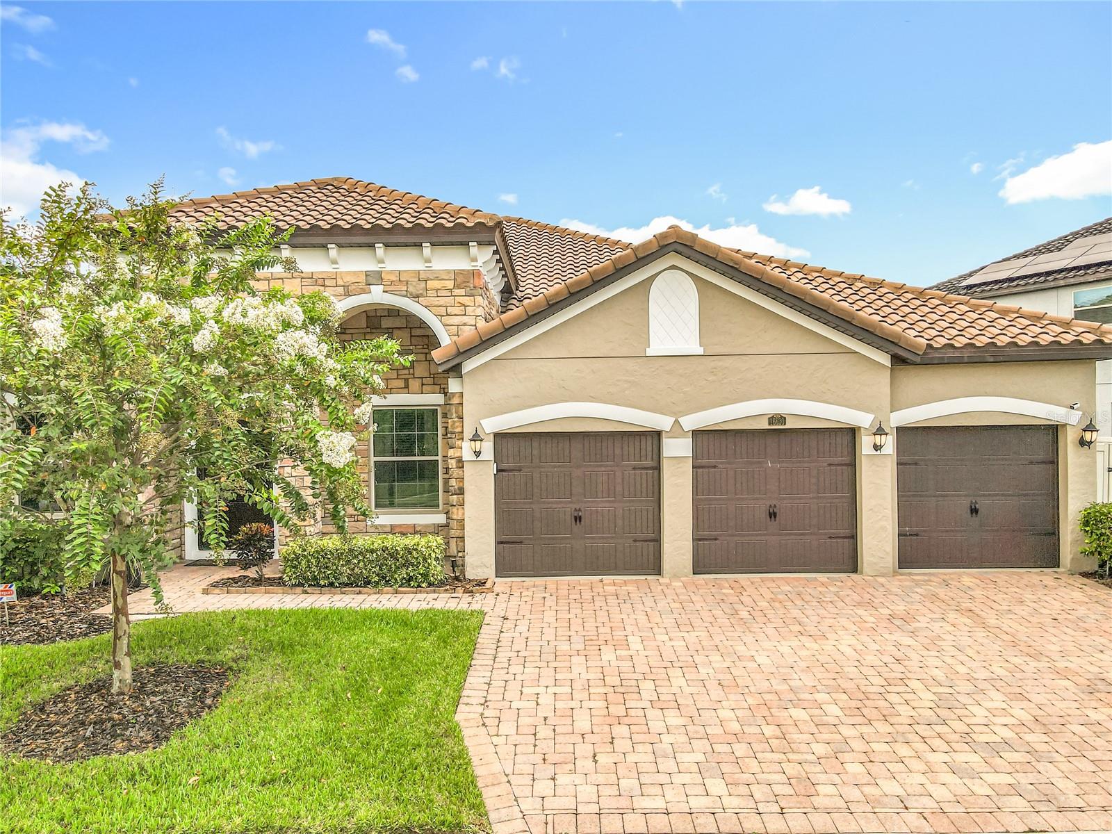 Welcome to Twinwaters—an elegant one-story residence just minutes from Winter Garden Village and historic Downtown Winter Garden. Thoughtfully upgraded and designed for effortless living, this 4-bedroom + private office/den home greets you with a double-door study off the foyer, a convenient guest bedroom and full bath up front, and an inviting formal living/dining space featuring tile flooring throughout the main living areas. At the heart of the home, the open kitchen, dining room and family room make entertaining a breeze. The chef’s kitchen boasts upgraded cabinetry, stainless appliances, a large electric cooktop with tiled backsplash and double oven and microwave, butler’s pantry with wine cabinets and more, walk-in pantry, and not only do you get 2 islands, one of them is an oversized island with generous seating. Under the sink reverse osmosis (RO) system included. Fresh neutral colors, high ceilings, and large-format light tile continue into in the main living area. The primary suite is tucked at the rear by the kitchen for maximum privacy. The spa-style bath offers separate granite vanities, soaking tub, walk-in shower, private water closet, and an expansive built-in walk-in closet. Extra-large closets are found throughout, with two additional bedrooms set on the opposite side of the home for a true split plan. Everyday convenience shines in the laundry room with cabinetry and utility sink and the 3-car garage with upper/overhead storage for added convenience. Set on an oversized lot, the outdoor living is exceptional: a screen-enclosed paver lanai with a full outdoor kitchen, —grill, sink and mini-fridge included—perfect for year-round gatherings. New additions: Top of the Line whole house Water Filtation system and goreous light fixtures in the dining and kitchen area. About a block behind the home you’ll find Twinwaters’ large community pool and playground. The neighborhood borders the shores of Johns Lake and is ideally situated near shopping, dining, attractions, and all major roadways. Twinwaters is a sought-after enclave with recent $1M+ closings—enjoy the luxury lifestyle near Johns Lake. Nature & water lovers: Scrub Point Preserve sits across Johns Lake—a ~93-acre protected peninsula managed by the Lake County Water Authority—typically accessed by boat or kayak and known for its rare/native species and occasional guided outings. A great perk for paddlers, birders, and outdoor enthusiasts who will love living this close to the water. Beautiful upgrades, fixtures, a smart private layout, and resort-style outdoor living—this is the one your looking for. Call for a private showing.