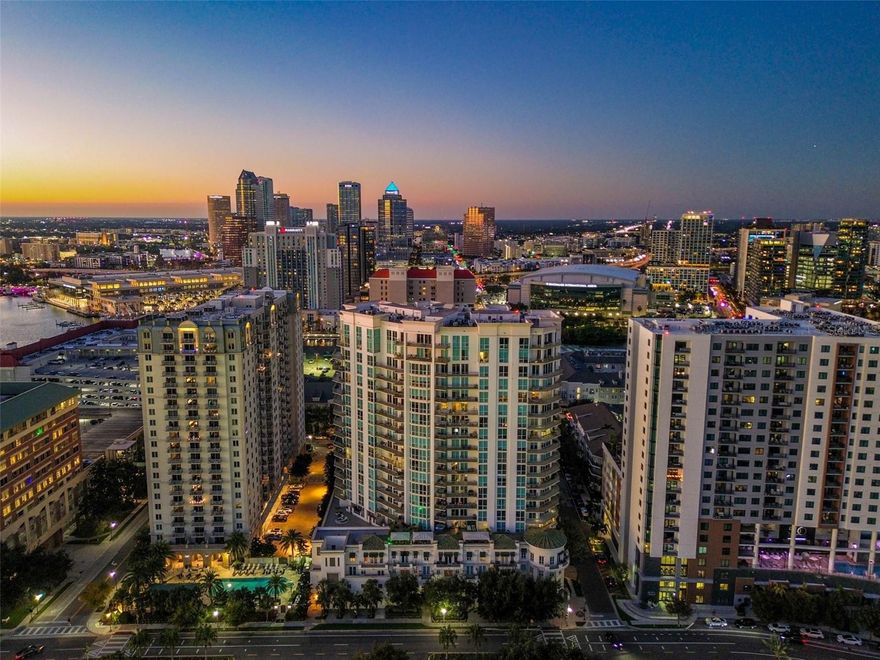Poised atop the 20th floor of The Plaza, The Arch at The Plaza is a 3,942-square-foot masterpiece offering panoramic views of downtown Tampa and Hillsborough Bay. Reimagined from the studs in 2024 (finished in 2025), this private-elevator residence showcases extraordinary craftsmanship, architectural millwork, and refined modern design. A grand marble foyer with chandelier opens to formal living and dining spaces framed by archways, fireplace, and access to a private balcony with skyline views. The chef’s kitchen is a showpiece with dual islands, waterfall marble countertops, Wolf 48" dual-fuel range, Sub-Zero refrigeration, dual Miele dishwashers, farm and prep sinks, and bar seating—perfect for entertaining. The primary suite is a serene retreat with floor-to-ceiling windows, balcony access, custom walk-in closets, and a spa-inspired bath featuring dual vanities, soaking tub, and walk-in shower with body jets. Two additional bedrooms, one en-suite, provide flexibility for guests or a private office. Smart-home integration controls lighting, climate, and audio throughout. Included are three deeded parking spaces and two climate-controlled storage units. Residents of The Plaza enjoy 24-hour concierge and valet, resort-style pool and spa, fitness center, guest suites, and meeting rooms. With its complete 2025 renovation, designer finishes, and 360-degree views, The Arch at The Plaza stands as one of Tampa’s most exceptional residences.