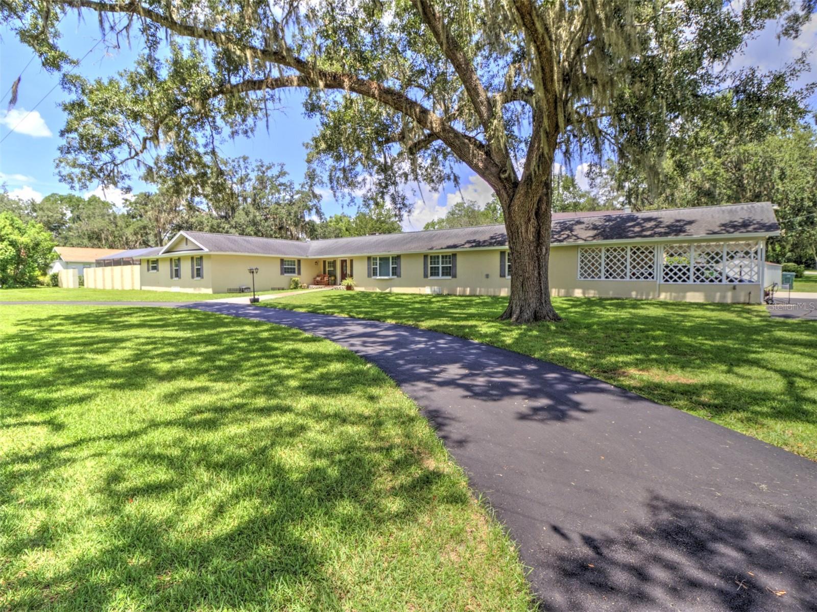 Wonderful Woodfield's home. This 4-bedroom with 4.5-bathroom home in southeast Ocala is located on an oversized lot and on a scenic street lined with tall great oak trees. The front of the home has a circular driveway and a driveway into the double carport and single garage on the end of the home for ample parking. As you walk into the home you step into a large open foyer. To the right is the living room that looks out to the front yard through the large windows. To the left is the hallway to the bedrooms and huge swimming pool. The swimming pool is 20 X 40 with a built-in hot tub that cascades into the pool. There is an ample sized pool deck and a covered sitting area under an oversized ceiling fan. The entire area is screened in on top of the surrounded wall. In the corner of the pool deck is a full bathroom for all your pool guests. 3 of the bedrooms have their own window doors with built-in blinds to the pool area. There are French doors that lead back into one of the bonus rooms that could have many uses. Also on this side of the home are 4 bedrooms and 3 full bathrooms and all have double sinks. 2 of the bathrooms have been updated beautifully. The Primary bedroom is huge, plenty of room for a king-sized bed and living room set. It also has a private en-suite. Walking ahead from the foyer is the family room with a gas burning fireplace. Off the family room through the double doors is another bonus room currently used as a media room and could easily be used as a 5th bedroom. Tot the right of the family room is the kitchen complete with large cooktop island, solid wood cabinets, duel built in ovens and stainless-steel appliances. The kitchen overlooks the formal dining room with a 2nd gas fireplace. off the kitchen is the home office, possible 6th bedroom, and the pantry and half-bath. There is also access to the utility area/laundry room that is under heat and air with French doors to the double carport! This home has many extras like crown molding, Built-in natural gas Generac Generator, shed, .73 acres. Home is also located in the legal golfcart area of Ocala. You can drive your cart to the downtown area and the many parks. MUST SEE!