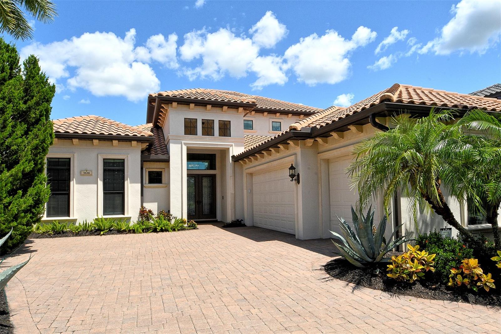 Welcome to this stunning, custom-built Arthur Rutenberg residence, where timeless elegance meets modern luxury. Tucked into a serene cul-de-sac which overlooks a magnificent fairway in the sought-after Village of Country Club East in Lakewood Ranch, Florida. The homeowner is a retired architect and made the decision to further enhance this Arthur Rutenberg Sienna Floorplan before the start of the home's construction. From the moment you enter through the stately double doors, you're greeted by soaring, embellished tray ceilings and expansive spaces filled with abundant natural light, creating an atmosphere of effortless sophistication and warmth. At the heart of the home, the open concept living area seamlessly transitions to the outdoors through a moveable wall of glass, revealing an expansive covered lanai designed for year-round enjoyment. Here, no detail was overlooked: an outdoor cabana/kitchen, a sleek LAP Pool, a bubbling SPA, tranquil fountain, cozy seating area with fireplace, and roll-down shades for privacy—all set against a serene backdrop of lake and golf course vistas—make this outdoor space an entertainer’s dream. Inside, the gourmet kitchen is a true showpiece, featuring floor-to-ceiling custom solid wood cabinetry, striking stone countertops, high-end appliances, a wine fridge, and an adjacent wet bar that makes entertaining a breeze. The home offers three bedrooms plus a private den, including a luxurious primary suite with a spa-inspired bathroom and custom-designed walk-in closets tailored for both form and function. Upstairs, the media room offers the ultimate retreat with a large screen, tiered theatre seating, its own wet bar with refrigerator, and a covered screened porch offering sweeping golf course views. Whether hosting movie nights or enjoying quiet evenings, this space offers comfort and style in equal measure. A tile roof crowns the home’s sophisticated curb appeal, while the oversized three-car garage includes custom organization systems and a whole-house central vacuum for modern convenience. The neutral color palette throughout offers a perfect canvas for personal style, while the mature, lush landscaping adds beauty and privacy to the grounds. The community's, residents can enjoy a clubhouse with member dining, a resort-style pool, fitness center, tennis courts, pickleball, a dog park, and of course, a pro shop. Every inch of this home reflects an unwavering commitment to quality, with no expense spared in its creation. This is more than a home—it is a statement of taste, luxury, and architectural excellence.