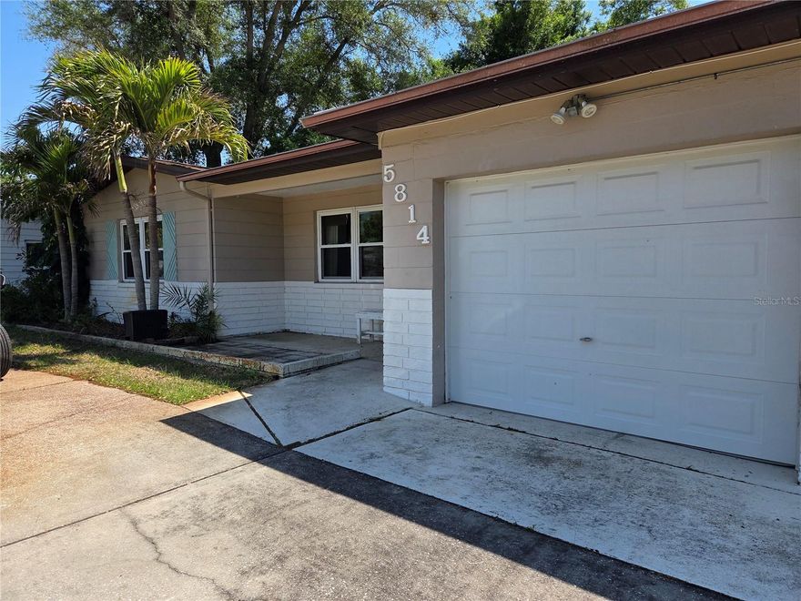 Here's your opportunity for 3 bedrooms, 2 bathrooms, indoor laundry, attached garage and a circle drive all on a large lot in Gulfport. There's a bit of charm here with warm wood tones and cove ceilings in the main living area plus the Saltillo Tiles (with signature footprints)in the primary. There are french doors from the primary bedroom leading you to the huge patio, and privacy fenced backyard. Dream big with plenty of room for a pool and still park a boat. Take your bike to Gulfport's quaint shopping, dining and beach district, the marina, clam bayou park, and nearby bike trails leading all across the county.  This home is just a 10 minute drive to the Beaches or downtown St. Pete to enjoy all the area has to offer.