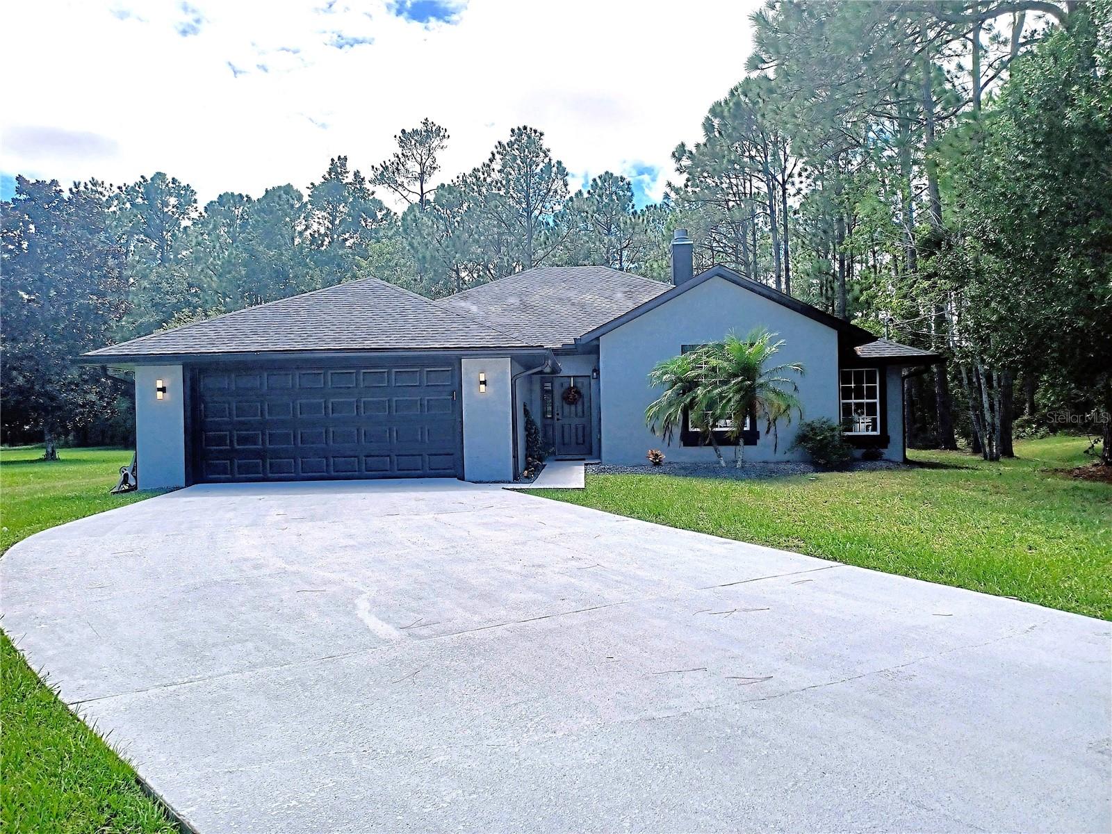 JUST COMPLEATED, FULLY RENOVATED, one of a kind beautiful home in the desirable Pine Lakes Country Club community. This 3 bedroom, 2 bath, 2 car garage offers you a brand new and a redesigned home. Brand new roof, luxury vinyl flooring in main area and hallway that is 8mm thick with a 22ml wear layer in all areas except the 2 baths with porcelain tile. Fully redesigned kitchen including an entire wall removed to give you the open floor plan. Kitchen with soft close cabinets, quartz counter tops and a full beautiful coffee bar with even more custom cabinets and a mini fridge. Wait till you see in the pictures, the beautiful long island with farmhouse style sink. Both Primary bath and second bath have been fully redesigned and renovated with dual sinks, cabinets, flooring, added shower in Primary Bath, soaking tub and beautiful lighted mirrors. Primary bath offers a separate toilet area behind a door for your privacy. Extended Lanai partially under roof has all new pavers and enjoy the privacy of the woods behind this home. Throughout the home you will see all the new recessed lighting, new 6" baseboards, fully painted inside and out including a sealed driveway and garage floor with a code pad on the exterior of garage door and new landscaping. All renovations and design were done by a custom builder and designer, and you will see all the moment you walk into the front door. Bathrooms and kitchen offer high end fixtures, and there's even a redesigned wood burning fireplace in the great room for the chilly Florida evenings. This is truly a one of a kind home in the desirable Pine lakes Country Club Community. Come see for yourself and I know for sure...you will fall in love.