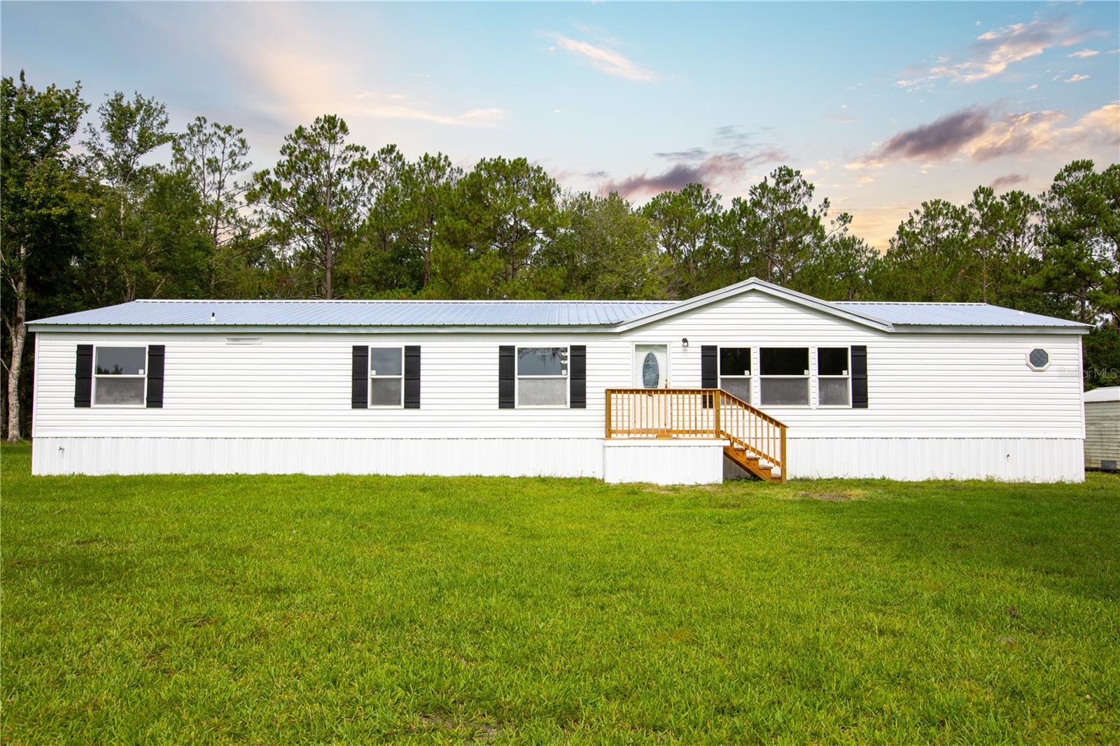Enjoy rural living at its finest. 4.11 acres of tranquility. Enjoy the lightning-bug show every night, plus constant view of wild turkey, and deer. This listing has a priceless sky view that looks like a movie scene. As if the land wasn't enough, there is a newly remodeled 4/2 MH on site, with TWO living rooms, formal dining room. Tons of updates, including roof, water heater, HVAC, appliances, showers/tub, cabinets, light fixtures, flooring and SO MUCH MORE! LIVESTOCK WELCOME!