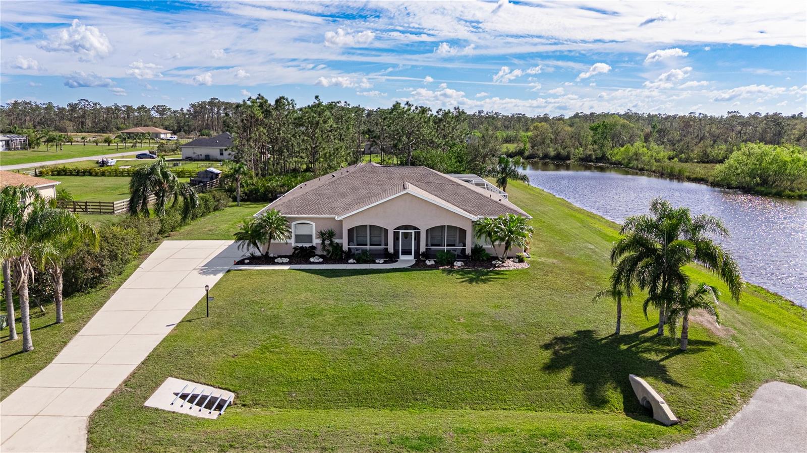 Discover the perfect blend of luxury, privacy, and natural beauty in this stunning 4-bedroom, 4-bathroom lakefront home, nestled at the end of a quiet dead-end street on just under an acre of serene, forested property. With breathtaking water views and a peaceful preserve behind, this home offers complete privacy, ensuring the ultimate tranquility. Thoughtfully positioned, the home sits safely elevated high above the retention pond, providing both stunning scenery and peace of mind. Designed with both comfort and functionality in mind, the spacious split floor plan allows for a master suite tucked away from the guest bedrooms for added seclusion. The master suite is a retreat in itself, featuring three closets (including a walk-in and linen), dual sinks, an onyx countertop, a jacuzzi tub, a walk-in shower, and stunning water views from every angle. Three of the four bedrooms include en-suite bathrooms, while the fourth bath is perfectly positioned for guests, with direct access to the lanai for seamless indoor-outdoor living. All bathrooms feature elegant marble countertops, adding a refined touch throughout the home. The heart of the home is the expansive kitchen, complete with stone countertops, ample storage, a pantry, and a new refrigerator (2022), all while offering beautiful water views. The kitchen opens into casual and formal living spaces, creating an ideal environment for entertaining, enhanced by an indoor/outdoor speaker system. Large windows and sliding glass doors flood the home with natural light, enhancing the open feel and offering easy access to the lanai. Outside, enjoy the ultimate in outdoor living with a heated saltwater pool, spa, outdoor shower, and a separate enclosed garden area. The fully screened lanai ensures a peaceful and secure space to relax, entertain, or enjoy al fresco dining, while the private outdoor areas are perfect for embracing the surrounding nature. This property is zoned agricultural (not residential), so chickens, goats, and other small livestock are welcome if desired. This home has been thoughtfully updated with major improvements, including a new roof (2023), new Trane HVAC system with upgraded soft start (2023), new hybrid water heater (2023), and a new well pump (2022). Additionally, all smoke alarms throughout the house and a carbon monoxide detector were installed in 2024, with batteries and units designed to last 10 years, ensuring safety and peace of mind. Located in the up-and-coming area of Myakka City, this home offers the perfect balance of seclusion and convenience. It's just a short drive to shopping, dining, and local parks, including Myakka River and Lake Manatee State Parks. This property comes with a transferable business permit, previously operating as an Airbnb retreat, offering the potential for passive income or future resale value. Whether you're seeking a peaceful retreat, an investment opportunity, or both, this home presents an exceptional chance to enjoy the best of both worlds—privacy and tranquility, with endless possibilities for use. Nestled in a prime location with easy access to Lakewood Ranch, Waterside Place, UTC Mall, Boutique Shopping, Airports, and Beautiful Parks - offering both convenience and lifestyle at your doorstep.