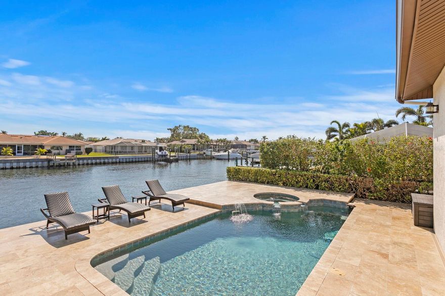 Nestled in the prestigious Venetian Isles, this Modern Mediterranean home offers 90 feet of deep-water frontage with direct access to Tampa Bay, delivering the best in single-level living. Custom-built in 2007 and ideally positioned on the east side of the street, this home boasts a thoughtfully designed layout, where three of the four bedrooms feature en-suite baths. The open-concept design is perfect for both everyday living and entertaining, featuring a formal dining area, an eat-in kitchen, and a spacious island with ample seating. A Wolf gas range and a stylish coffee bar complete the gourmet kitchen. The primary suite serves as a private retreat, offering a separate seating area with serene views of the pool and water. The luxurious primary bath includes dual vanities, a sit-down dressing area, and a charming clawfoot tub, while the expansive walk-in closet is thoughtfully organized and even includes a second laundry area. A dedicated office with built-ins and water views enhances the home’s functionality. Elegant details such as 10-foot ceilings, crown moldings, plantation shutters, and travertine flooring throughout create an inviting ambiance, seamlessly leading to your dream waterfront oasis. Enjoy alfresco dining in the screened-in outdoor kitchen, equipped with a DCS stainless grill and Viking smoker, while overlooking your private dock with triple boat lifts. The travertine-surrounded saltwater pool and spa provide the perfect vantage point to observe manatees, dolphins, and coastal birds, all while soaking in Florida’s endless sunshine. A grand three-tier fountain welcomes you at the circular driveway, offering ample off-street parking alongside a spacious two-car garage with additional storage. A 24KW Generac Air-Cooled Standby Generator with a 200Amp Transfer Switch was installed 7/ 2025. HVAC's (2024), Tankless HW (2022). This is truly a must-see waterfront retreat!