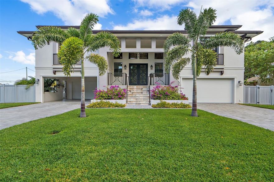 Discover unparalleled luxury in this custom-built masterpiece nestled in the prestigious Snell Shores neighborhood of Northeast Park. This extraordinary 3,876 square foot residence, situated on a corner lot, boasts 4 bedrooms, 3.5 baths. Built as a two-story block reinforced construction, the home's exceptional build quality was proven during Hurricanes Helene and Milton, emerging unscathed and fully powered throughout extended outages with its impressive 21.6 kW Tesla solar system with three powerwall batteries. Premium features including solid core doors, custom California Closets, and a gourmet kitchen equipped with high-end Thermador and Subzero appliances. The oversized Quartzite island with black surround granite serves as the kitchen's centerpiece, perfect for culinary enthusiasts. The Savant Home Automation system, along with strategically placed speakers and Samsung "The Frame" TVs, offers seamless smart living, while an LED fireplace adds to the ambiance. The home features two 560-square-foot covered lanais - one upstairs accessible from the kitchen, living room, and master bedroom and one downstairs - both offering spectacular views of the stunning resort-style custom oasis. The outdoor paradise centers around a custom 41-foot pool with an integrated 7' hot tub and relaxing waterfall feature. The elegant silver travertine pool deck provides the perfect setting for outdoor entertaining and relaxation, while lush landscaping creates a serene backdrop for this outdoor retreat. Car enthusiasts will appreciate the climate-controlled garage space, accommodating up to 9 vehicles with two double front doors and a 1.5-car width side entrance, offering the ultimate in collector's storage and display. A Tesla EV charger in the garage complements the home's commitment to sustainable living. This Snell Shores gem represents the pinnacle of sophisticated living, blending durability, sustainability, and opulence. Additional luxuries include Restoration Hardware lighting fixtures, ceiling fans throughout, luxury vinyl plank and tile flooring, and an elevator shaft for future installation. The home's thoughtful design extends to its hurricane-rated storm windows, doors, and garage doors, ensuring peace of mind without compromising on style. With its perfect balance of indoor comfort and outdoor allure, this residence offers a lifestyle defined by elegance and modern convenience. Schedule your private tour today and experience the epitome of luxury and sustainability in one of St. Petersburg's most coveted neighborhoods.
