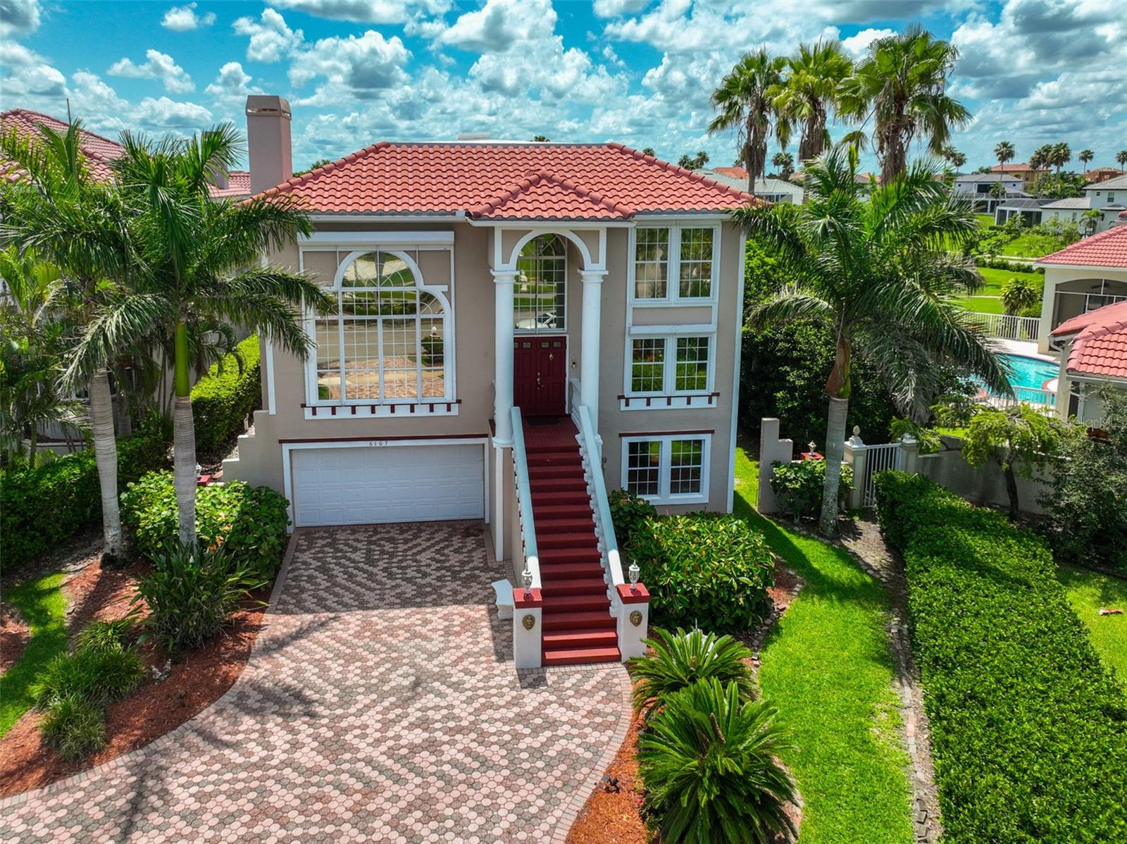 Experience premier waterfront living in the guard-gated community of Andalucia on the shores of Tampa Bay! This gorgeous custom-built waterfront home presents a tri level "Feng Shui" architectural design boasting 5206 sq.ft. of harmonious contemporary living space for everyone. Perfectly positioned within steps of the community clubhouse enjoy an impressive sparkling pool and the most stunning sunsets overlooking Tampa Bay! The home features 4 bedrooms, 5 bathrooms, den, studio, loft and the ultimate recreational room. Showcasing three levels of indoor-outdoor living area each enhanced with spacious rooms, expansive balconies, spectacular canal and bay views. The beautiful tile roof was completely redone in 2023 "atop" you will find your best kept secret of all, more views! Your personal visit awaits manatees and dolphins at your private dock with all trek decking, lower landing platform, and a 10,000 lb. boat lift (2022). From the circular paver driveway to the grand expansive two-story foyer, a light-filled entry with soaring ceilings, and marble tile floors accompanies a formal dining room and living room, accented by a wood burning fireplace. The family room and den presents decorated custom Mahogany built-ins, double glass sliding doors lead to the large screened in balcony and the outdoor cooking area. Inside the gourmet kitchen boasts all stainless steel appliances, granite counters, a center island cooktop, newer refinished cabinets and an added touch of recessed lighting. Thoughtful design greets you in the primary suite with a modern aesthetic, ensuite bathroom, deep soaking spa tub, jade marble tile walk-in shower, double vanities and walk-in closets. The grand upper level includes 2 bedrooms and 2 full baths, sleek updated showers with a primary suite opening onto an elongated wraparound balcony connecting rooms giving unparalleled views of the grounds. Encompassing the studio and loft compliments the voluminous living space to enhance family life. The first floor ties it all together offering an expansive recreation room, fourth bedroom, a convenient full outdoor bathroom and a two car garage. Expanding to the canal, the boat dock entails night ambiance illuminated green underwater lights and bench seating to enjoy fishing. Andalucia offers a waterfront community on Tampa Bay, 24-hour manned guard gate, marina, tennis courts and a pier with the most gorgeous sunsets. The location is great, being close to nearby waterfront restaurants, beaches, and Tampa. Don't miss your chance to experience this gorgeous home for yourself! Schedule your appointment today!