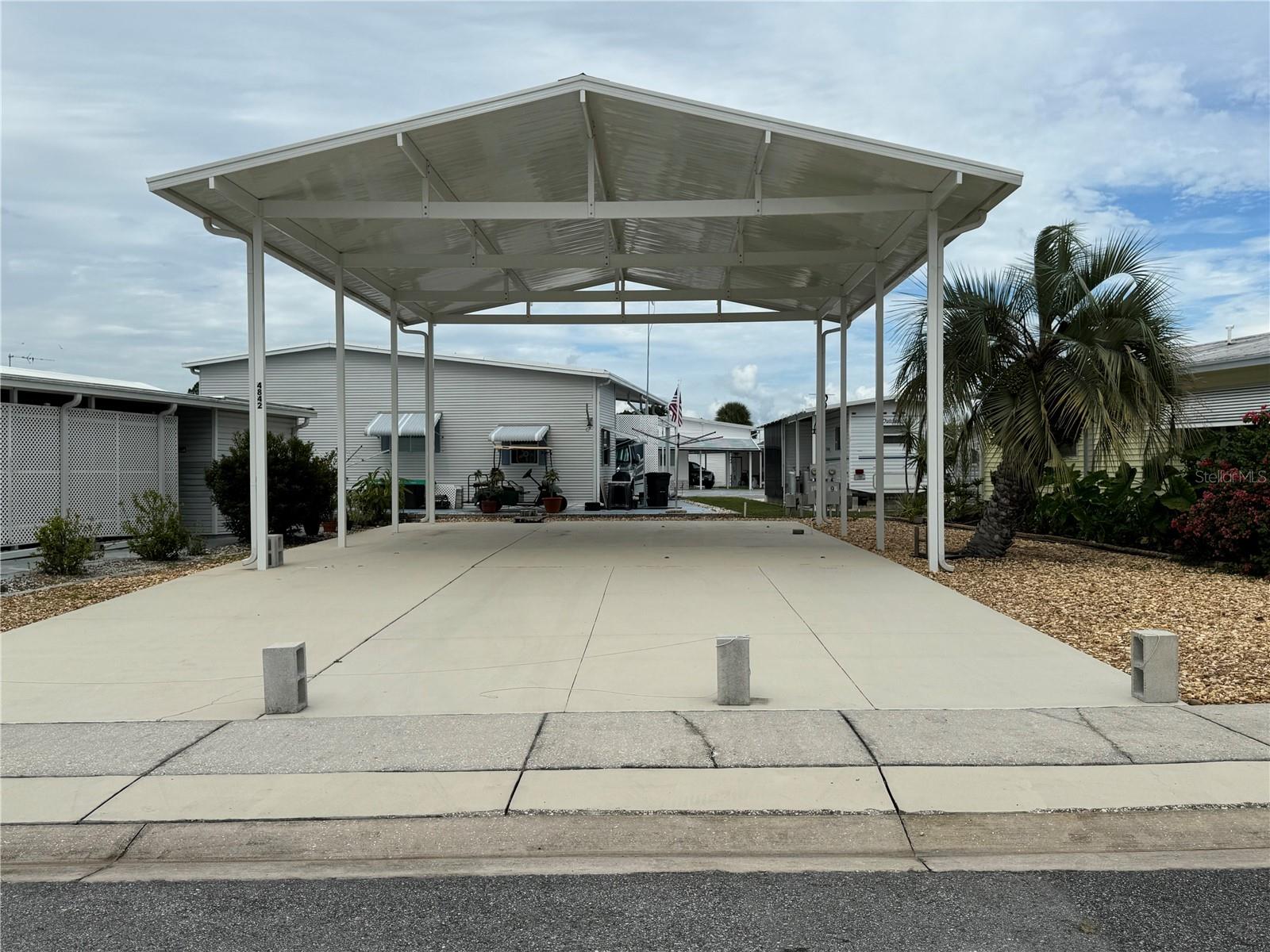 This ready-to-go RV site is level, concreted and has an engineering-designed full roof-over and is equipped with 50-amp electric service and sewer. It is in the center of American Condominium Parks, an RV condominium park where you own the land and a portion of the common elements. Come experience the RV lifestyle or bring in a park model home for more permanent living. American Condominium Park is a 55+ gated community with heated pool, clubhouse, exercise room, sauna, hot tub, tennis/pickleball courts, horse shoe pits, shuffleboard, and many more amenities. A friendly active community with dances, dinners, and entertainment. Perfect for full-time affordable living and cost-effective for snow birds. No rent as you own the land. Reasonable monthly fee that maintains the common elements and amenities for your use. As an RV subdivision this property has full hookups. Just park your RV and enjoy!