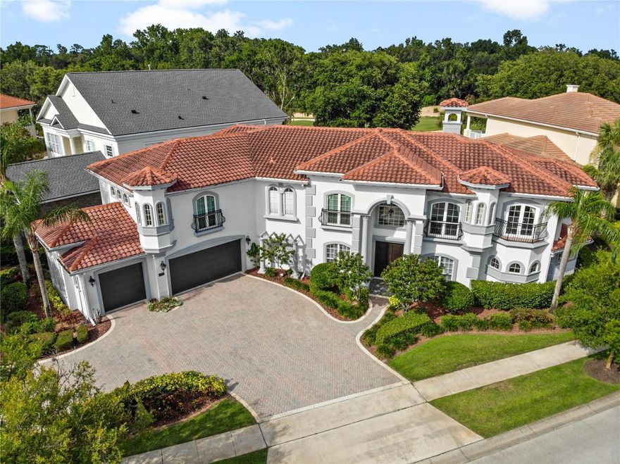 Introducing a stunning custom-built Mediterranean-style home with 4,925 sq. ft. of living space, located in the prestigious Reunion Resort. This 5-bedroom, 6.5-bath estate features a grand circular driveway, elegant double doors, and a striking foyer with a spiral staircase and two-story ceilings adorned with crown molding. The main floor boasts a formal living room, a library with custom bookcases, a dining room with a gas fireplace and French doors, and a gourmet kitchen equipped with custom cabinetry, granite countertops, a large island, wine cooler, stainless steel appliances, and a walk-in pantry. The spacious master suite offers pool views, custom walk-in closets, and a luxurious bath with a spa tub and dual shower heads. An additional ensuite bedroom with pool access is also on the main level, along with the primary laundry room. Upstairs, you’ll find a home theater with surround sound, a wet bar, a balcony, and three ensuite bedrooms. Another staircase leads to a game room with its own bath, which could double as a sixth bedroom. The fully fenced outdoor space features a pool, spa, lanai, and summer kitchen, perfect for entertaining. Recent upgrades include a new pool heater, tankless water heater, and two AC units (2023). Located in a gated community near championship golf courses, world-class amenities, theme parks, and beaches, this home is also zoned for short-term rentals. Schedule your private showing today!