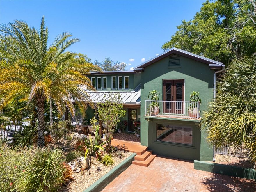 Welcome to this beautifully appointed residence full of charm and warmth, situated in the highly sought after Plant High School district and not in a flood zone. Outstanding curb appeal welcomes you immediately with a classic brick driveway leading to a peaceful covered front porch featuring a remarkable wood ceiling and natural landscaped front yard. Step inside to discover a thoughtful interior elevated by large profile ceramic tile floors, gorgeous wood framed windows outfitted with custom plantation shutters, craftsman baseboards and doors, smooth drywall and a curved staircase. The inviting living room, centered around a stylish brick fireplace, flows seamlessly into a bright and abundant redesigned kitchen. This culinary space is perfectly equipped with an induction cooktop, built in oven and microwave, a sleek farmhouse sink, and a truly oversized island that cleverly incorporates a dedicated table seating area for casual dining and entertaining. The home continues to impress with a luxurious primary bedroom that boasts its own private front facing balcony for morning coffee or evening relaxation. The secondary bedrooms offer fantastic versatility, in flexible spaces that could be an office, study, or craft room, in addition to large bonus room on the first level. The guest bedroom has a wood deck overlooking the scenic backyard. The upstairs bathroom features a chic tile wall, timeless clawfoot bathtub, and two sinks, while the downstairs has a elegant half bath, and the second full bath. Key updates include a metal roof, and replaced windows, with remodeled kitchen and bathroom aspects in 2022. The private backyard oasis: highlighting an aesthetic wood fence, tall landscaping, complimented with a low maintenance turf backyard designed for year round enjoyment, comes complete with a covered seating area perfect for outdoor gatherings. Conveniently located in the Palma Ceia area of South Tampa, just blocks away from Bayshore Boulevard, and close to Hyde Park Village, downtown Tampa and Tampa International Airport.