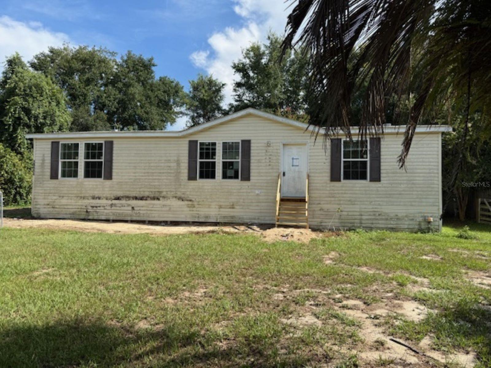 Bring your boat! Historic Carney Island is approx 1.5 miles away! This lovely 3bd/2ba double wide offers an open floor plan with Living Room, Dining Room and gormet kitchen in one huge area! This allows you to enjoy family activities as you prepare you daily meals. It has a shed for additional storage. Whether you love fishing, boating, picnicing or just relaxing and enjoying the breathtaking views of Lake Weir, you have truly found paradise. It needs some TLC but has unlimited potential. Hurry, this will go fast!