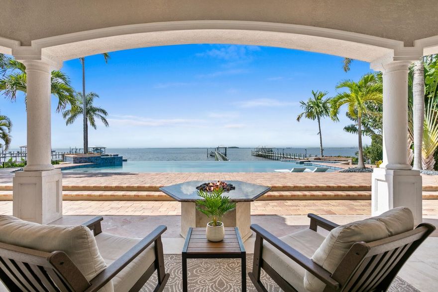 Exquisite Waterfront Estate – Meticulously Remodeled & Reimagined. Nestled in the exclusive gated enclave of Mustique Bay, this magnificently remodeled waterfront estate offers an unparalleled blend of luxury, sophistication, and modern enhancements. Boasting exceptional living and entertaining areas indoors and out, with breathtaking views at every turn. Set on an expansive 100-foot-wide, .66-acre open Bay lot, this home has been transformed with extensive updates that elevate its elegance and functionality, making it one of the most remarkable residences on Tampa Bay. A gated entry and palm-lined drive welcomes you to a home that lives primarily as a single level, featuring new wood flooring throughout, modern lighting, and refined finishes. The gracious entryway leads to expansive living and dining areas with soaring ceilings and walls of glass that frame breathtaking waterfront views. A new stone feature wall with a fireplace creates a stunning focal point in the family room, adding warmth and architectural interest. The Chef’s kitchen has been completely redesigned, now showcasing Taj Mahal quartzite countertops, SubZero and Wolf appliances, a new wine refrigerator, custom cabinetry, and a spacious center island—all blending seamlessly into the open-concept living space. The grand FIRST-FLOOR master suite offers a tranquil retreat with spectacular Bay views, a double tray ceiling, and an opulent spa-inspired bath featuring a deep soaking tub, an expansive shower, and custom-designed finishes. Additional living spaces include a formal dining room, den/office (optional bedroom) and two additional first-floor guest suites with en-suite baths. Upstairs, a bonus/game room features a gracious waterfront terrace, along with an additional guest en-suite, half-bath and a fully rebuilt balcony with new tile and railings for a private guest haven and recreation. The outdoor living experience is truly resort-worthy. The saltwater infinity pool has been remodeled, featuring a new infinity edge, stunning new tile work, and a gas/electric hybrid pool heater. The covered outdoor living area now boasts a stone feature wall with a fireplace, along with a completely updated summer kitchen and built-in grill. A fire pit and multiple seating areas provide the perfect setting for waterfront gatherings, while a generous private dock, complete with a covered lift, new 20k boat lift motor and paver walkway provide direct access to Tampa Bay’s premier boating lifestyle. Additional top-tier upgrades include three new A/C units with updated ductwork, water softener and reverse osmosis system, landscape lighting and exterior fans, garage door system and gate controller, and upgraded window treatments. This spectacularly reimagined estate represents the pinnacle of waterfront luxury and modern elegance. Capture this extraordinary opportunity to own one of Tampa Bay’s most exclusive and meticulously remodeled properties and embrace all that Apollo Beach has to offer. This popular waterfront community delivers an abundance of recreation on and off the water with its central location and easy access to beaches, shopping, dining, parks, Tampa, St. Petersburg and Sarasota. Please view Virtual Tour for full Property Video and Floor Plan. BRAND NEW ROOF INSTALED JUNE 2025.