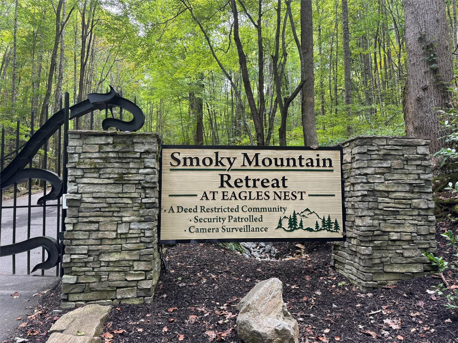 Discover the charm of mountain living with this .83-acre homesite in the highly desirable Smoky Mountain Retreat at Eagles Nest. Perfectly sized for your dream cabin or mountain escape, this lot combines sweeping mountain views with the peaceful privacy of a wooded setting.
Inside this gated community, you’ll enjoy exclusive amenities including a waterfall hiking trail, children’s playground, and a rustic gathering barn for events and celebrations. With two convenient gated entrances — one to Maggie Valley and the other to Waynesville — you’re only minutes from charming shops, restaurants, and year-round outdoor adventure. There is underground utilities, county water, fiber optics, cable, and internet are available for your convenience.
Whether you’re looking for a private getaway or a place to build a lasting family retreat, this .83-acre property offers both natural beauty and community living in one of Western North Carolina’s most coveted mountain destinations.