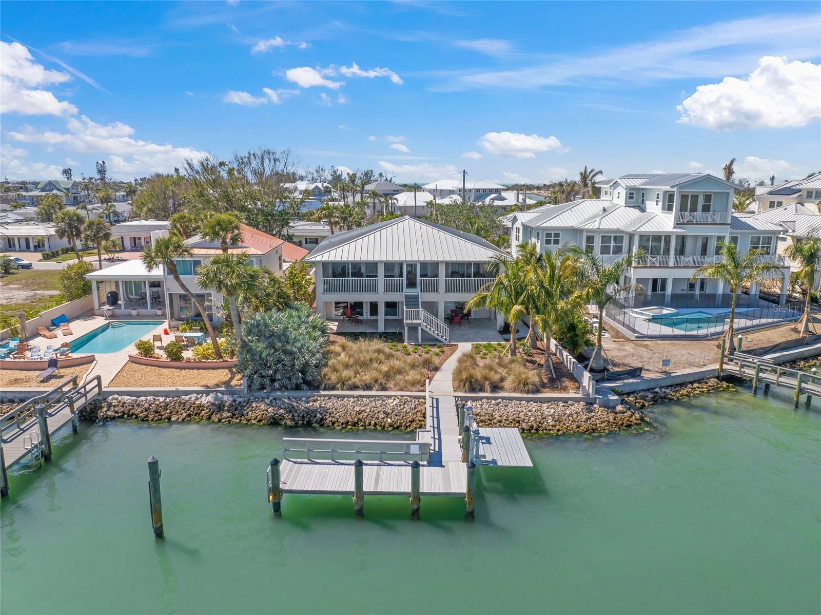 VENICE ISLAND WATERFRONT OASIS ON ROBERTS BAY. Welcome to your dream home on Venice Island, ideally situated on Roberts Bay with direct access to the Intracoastal and Gulf—no bridges! Just steps to the beach, South Jetty, Venice Yacht Club, and all the charm of island living. Hop on your golf cart and cruise to nearby restaurants, boutiques, the grocery store, and entertainment venues with ease.
The main living area is elevated on the upper level, offering panoramic bay views and an open floor plan that flows seamlessly. The covered porch is perfect for outdoor lounging and entertaining while taking in the views. Enjoy hickory engineered flooring, three spacious bedrooms, and two full bathrooms where the primary suite offers a private escape with breathtaking water views, lanai access, a walk-in closet, and ensuite bath.
The lower level offers incredible flexibility with a complete multigenerational living space/in-law suite, including a separate bedroom, full bath, living room, kitchen with breakfast area, lanai, private entrance and more stunning views!
This home includes impact-resistant windows and sliders, a durable metal roof, spray foam insulation and LED lighting for energy efficiency while providing peace of mind.
Enjoy the added convenience of storing your cars, toys, etc in the 4-car tandem garage. The possibilities are endless as there’s room for a pool and an elevator can be added if desired.
From your own backyard, take in the spectacular 4th of July fireworks, Christmas boat parade, and daily dolphin shows—a true waterfront lifestyle experience!
This is a rare opportunity to own a true gem in one of the Gulf Coast’s most coveted locations. 3D Tour, Floorplan and Video Available.