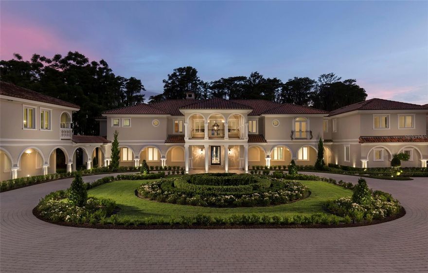 Commanding a rare 2.75-acre lakefront setting on the coveted Butler Chain of Lakes, this extraordinary Windermere estate is a true work of art. Recently completed after a meticulous, ground-up transformation, the residence showcases a level of craftsmanship, design integrity, and finish quality that is simply unrivaled in Central Florida. From the moment you arrive, the estate announces itself with undeniable presence. Grand entry doors open to a breathtaking interior defined by soaring 30-foot ceilings, dramatic architectural volumes, and a sleek, contemporary aesthetic softened by warm, bespoke materials. Walls of glass frame panoramic lake views, creating a seamless dialogue between indoor elegance and the natural beauty beyond. Designed for both refined living and grand-scale entertaining, the interior amenities rival those of a world-class resort. Highlights include a private spa sanctuary, fully equipped fitness center, state-of-the-art home theater, and an expansive game and entertainment lounge. The chef’s kitchen is a showpiece, thoughtfully designed for culinary excellence, intimate gatherings, or catered events, anchored by Wolf & Miele appliances, custom cabinetry, and flawless detailing throughout. The primary suite is nothing short of spectacular: a serene retreat offering commanding lake views, spa-inspired bath accommodations, and an atmosphere of complete privacy and indulgence. Every element of the home is enhanced by cutting-edge smart home technology, delivering effortless control, comfort, and security. A thoughtfully designed separate guest wing allows for exceptional flexibility, making the estate equally suited as a private family residence, an entertainer’s dream, or an inspired corporate retreat. Outdoors, the property unfolds into a private resort oasis. Impeccably manicured grounds lead to a private boat dock on the Butler Chain, a hidden garden retreat, and a stunning resort-style pool ideal for both relaxation and large-scale gatherings. Additional features include a putting green, a nine-car garage, and a detached guest house complete with its own kitchen, living area, and bedroom, perfect for extended guests or staff accommodations. A rare opportunity to own one of Central Florida’s most iconic and impressive lakefront compounds, where every detail has been elevated to the highest standard.