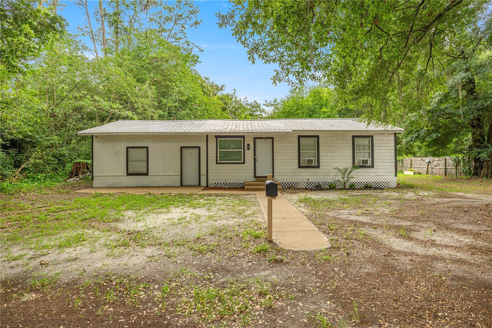 Welcome to this updated home in Reddick, FL, Offering updated finishes and excellent functionality. The main living space features new vinyl plank flooring throughout, fresh interior paint, and a remodeled bathroom with a tiled walk-in shower, a new toilet, and a new sink. Ceiling fans are installed in every room, and the fully equipped kitchen includes stainless steel appliances and laminate countertops. A second living space offers its own vinyl flooring, fresh paint, a half bathroom with a new sink, washer and dryer hookups, and a new barn-style sliding door. It also has a separate exterior entrance perfect for multi-generational living or rental income. Outside, the home boasts wood siding, a metal roof, a crawlspace foundation with a concrete slab, a 2-car garage, a cleared lot, and newer windows. This move-in-ready property is a rare find, offering both comfort and income potential. Call today for your private showing.