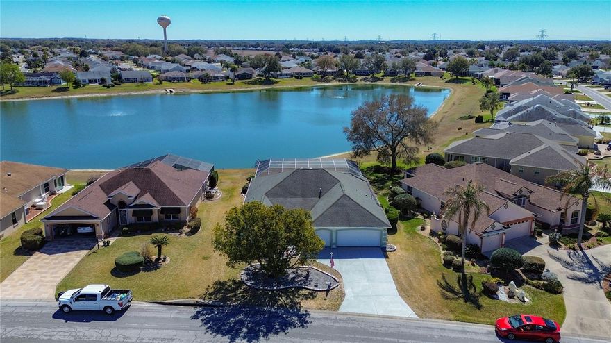 LAKE FRONT!! POOL HOME!!! BOND PAID!! Welcome to this beautiful, spacious, expanded, 3 bedroom 2 bath,  lakefront, pool home offering breathtaking panoramic water views and true Florida living at its finest. Situated on a premium waterfront lot, this spacious home features a screened-in private pool and covered lanai overlooking the serene lake — perfect for relaxing evenings and entertaining guests.
Step inside to an open and airy floor plan with vaulted ceilings, abundant natural light, and expansive living spaces. The large main living area showcases neutral tile flooring, architectural niches, and custom built-in shelving, creating both style and functionality. Sliding glass doors seamlessly connect indoor and outdoor living spaces while framing picturesque water views.The kitchen offers generous cabinet storage, ample counter space, a center island with sink, gas range, built-in microwave, and a bright breakfast nook surrounded by windows. The layout flows effortlessly into the main living and dining areas, making it ideal for gatherings.
The spacious Master bedroom features vaulted ceilings, a large walk-in closet, and an en-suite bath with dual sinks, extended vanity space, and abundant natural light. Additional bedrooms provide comfortable accommodations for family or guests.
Enjoy peace of mind with a 2-car plus golf cart garage, mature landscaping, and a beautifully screened pool enclosure. The backyard opens directly to the lake, offering tranquil views and a scenic setting for outdoor enjoyment. If you are looking for a spacious lake front home with your own private pool in The Villages. Look no further.. Schedule your showing today. Lets get you moved in and by the evening you can enjoy a night out at Spanish Springs Square, dancing, shopping and dining. Located only 2 miles from Spanish Springs, and only minutes from shopping, dining, medical etc. This wont last long!