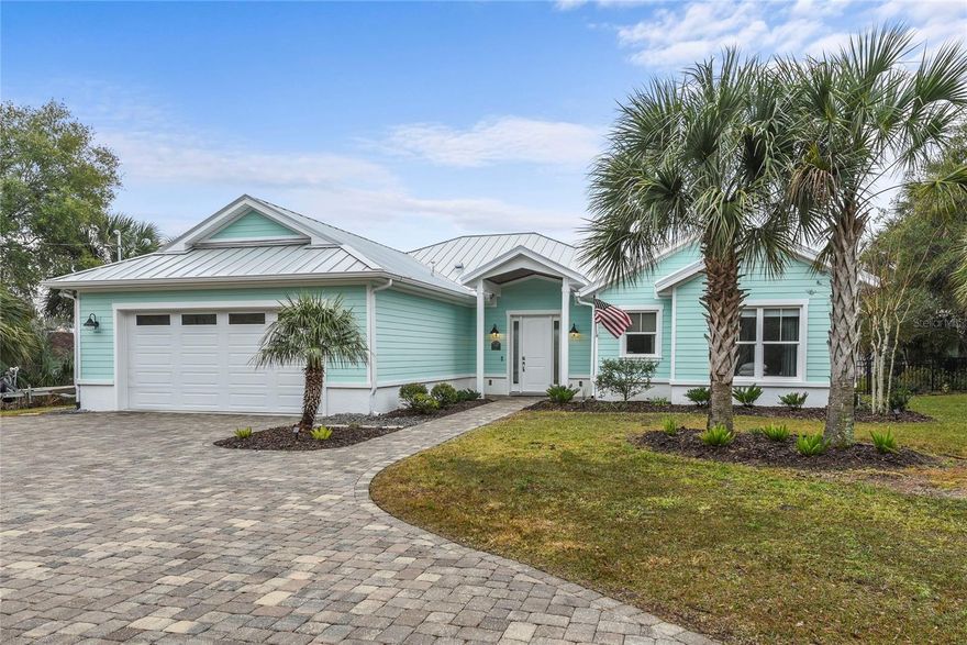 Extraordinary Custom Water Front Home perched high and overlooking Spruce Creek. This Spacious 3 bedroom, 2 bathroom home is the epitome of Florida Coastal Living. From the moment you enter the foyer, this Open Floor Plan home welcomes you into understated and truly elegant living spaces with wide open views to water, sky and the marshlands beyond. The Great Room includes spacious living, dining and kitchen areas. Each space offers water views and access to the adjacent large covered porch with motorized retractable screens. Beyond the porch are various patios, decks and stairs down to the dock. Each night's sunset can be enjoyed from a variety of vantage points. The dock includes water and electric, fish cleaning area, floating dock and a covered boat slip with 8,000 lb lift. Boat along Spruce Creek and out to the Intracoastal or explore the pristine marshlands. Back inside: the kitchen features solid wood cabinetry, quartz counter tops, gas range w/ convection oven, high-end appliances and an island complete with breakfast bar. Adjacent to the kitchen is a dry bar with more storage and custom butcher block wood counter top. The Open Floor Plan affords immediate access from kitchen to the spacious dining and living areas. The Split Bedroom Plan features a large Primary Suite with water views, large walk-in closet and an elegant en-suite primary bath featuring wood cabinets, quartz counter tops, custom tile work, double sinks and a large walk-in shower. On the opposite side of the great room you'll find two more bedrooms and a full bathroom with tub/shower, custom tile, tall wood vanity w/ quartz counter top. Convenient to the the living area is a spacious laundry room with washer/dryer, cabinets and hanging rack. From the kitchen you have immediate access to the over-sized 23x25 attached garage complete with it's own "split" A/C unit, work bench and electric supply for vehicle charging equipment. The home enjoys endless hot water with the propane tankless water heater. This 2018 built custom home also features a standing seam aluminum metal roof. Pictures do paint a thousand words so please check out the photos and virtual tour to fully appreciate this special, one-owner property. All measurements are approximate, and Buyer responsible for verifying all dimensions. Note: 2025 Property Taxes based on both Homestead and Disabled Vet. Status and should not be used to predict future property taxes.