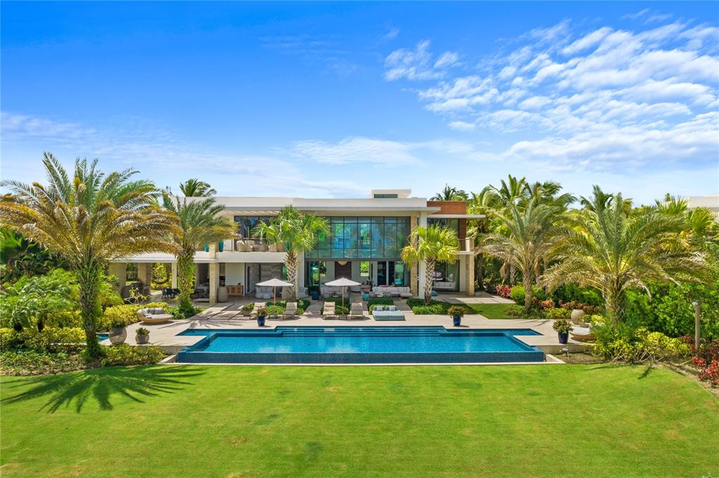 On Dorado’s most coveted street, overlooking the ocean and the rolling fairways of the golf course within the Ritz-Carlton Reserve sits an amazingly spectacular world class property. This ultra-luxurious home boasts 12,949 sq. ft. of utmost elegance in a 1-acre ocean front lot, with 5 bedrooms plus an independent guest bedroom suite. Distinguished by a unique modern design that beautifully combines nature and artistry, this is truly one of Dorado Beach’s most exclusive residences.
Everything shows exquisite attention to detail in this incredibly spacious home where high ceilings and natural light abound, from its impressive foyer to the grand living room with dramatic 24 feet high floor to ceiling glass doors opening to the expansive outdoor grounds boasting an extraordinary terrace with outdoor kitchen and a pool with jacuzzi overlooking the golf course and ocean. On the main floor, the home features 2 bedroom suites, both with outdoor showers leading to the beautifully landscaped and lush green areas. The home also features a gourmet chef’s kitchen with high-end appliances (Wolf, Sub-Zero, Miele) and Poliform cabinets. The villa’s modern floor-plan is ideal for entertaining since all the common areas open to the fabulous outdoor space via sliding glass pocket doors.
A dramatic glass wall staircase welcomes you to the 2nd floor floating over a beautiful water feature. Upstairs you will find 2 bedroom suites, a 2nd dedicated laundry room, an open office space with sitting area leading to the magnificent master bedroom suite that encompasses the entire 2nd floor right wing. The luxurious master suite has a private terrace where you can watch daily sunsets while listening to the sound of the waves plus an impressive his and hers walking closets and bathroom suite with outdoor shower.
On the main floor, home also features a mud room with half bath, an ample laundry room, a 4 car garage and 2 visitors parking spaces.
East Beach Villa #7 is being sold as is and turn-key. Property was decorated in 2017 by a well-known and local interior designer. Showings by appointment only with minimum 48 hour advance notice. Proof of funds is required.