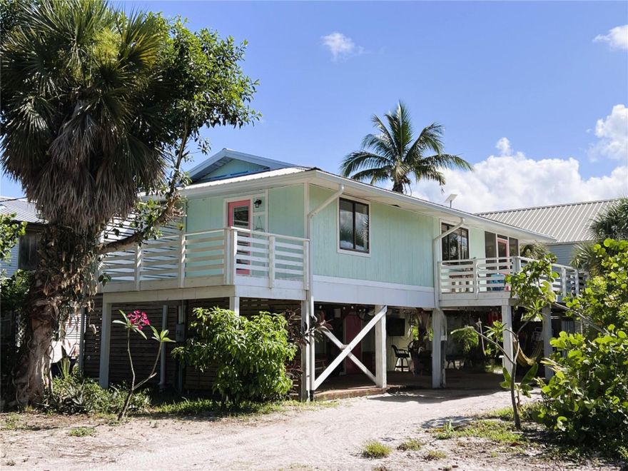This home is located on Little Gasparilla Island a bridgeless barrier island situated off the coast of the Cape Haze Peninsula. Accessible only by private boat or water taxi. The island offers a quiet, relaxing escape from the bustle of everyday life and is ideal for anyone seeking solitude and natural beauty. A bright, open floor plan, with vaulted ceilings, and soothing colors make this home a wonderful place to come and get away from the mainland madness. It has 2 bedrooms, 1 ½ baths upstairs, a bonus bedroom and bath with coffee bar and beverage cooler downstairs. The primary bedroom has a private balcony and ½ bath. The kitchen which has been remodeled has stainless-steel appliances, single, extra deep, oversized stainless-steel sink, an island, closet pantry, and plenty of room for entertaining. The large screened-in front porch has a seating area and plenty of room for outside dining, and the side porch is perfect for grilling. There is a large workshop/shed downstairs for all your tools, fishing tackle, and beach toys. The deck under the home is set up for hanging out, listening to music or watching a game. There is also an outdoor shower for when you come back from the beach or a day out on the boat. The a/c was just replaced, and the tankless water heater was replaced in 2024. The home faces east, so in the morning the home is flooded with soft morning light. The community dock this home uses is one of the nicest here on Little Gasparilla Island. Home comes with a 2007 Scout 187 Sportfish boat with 2007 115 Yamaha 4 stroke engine and utility golf cart. Enjoy fishing in our surrounding waters for snook, redfish, trout, snapper and more. We have miles of beautiful beach to walk and look for shells, fish, swim, or just sit and relax the day away. Come and see what a wonderful community Little Gasparilla Island is.