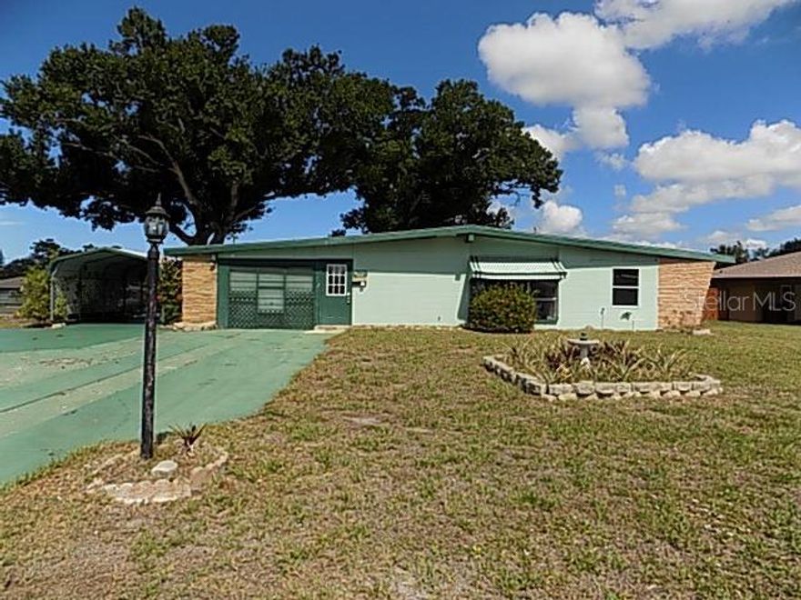 Adorable block home loaded with character offering 1,528 sq. ft., 3 bedrooms, 2 full bathrooms, vaulted ceilings, a 1-car garage, plus a 1-car carport with a circular driveway providing plenty of parking. Situated on an oversized .36-acre corner lot, the property is shaded by huge mature oak trees, creating a peaceful backyard setting. With a little vision and TLC, you can bring the sparkle back to this hidden gem. Located in Bayshore Gardens, residents enjoy an incredible array of amenities including a Jr. Olympic-size swimming pool, marina with private boat ramp and fishing pier, recreation hall, playground, picnic pavilions with BBQ grills, ball field, basketball and pickleball courts, plus numerous social clubs and activities, all just minutes from Sarasota Bay. HOA fee is paid through property taxes.