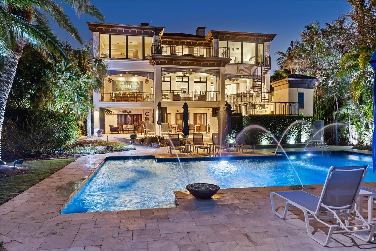 Welcome to Vivre Le Rêve (Living The Dream), an unparalleled estate located on one of the most coveted streets on Bay Island at the northern tip of Siesta Key. Nestled on the Freeling Drive Peninsula, this property sits on one of Sarasota's most secure and picturesque deep-water basins, just moments away from the Gulf of Mexico, with no fixed bridges obstructing your path to open water. Crafted by the renowned architect Clifford Scholz and constructed by Perrone Construction, this fully customized and enchanting residence embodies the elevated coastal lifestyle you've always envisioned. Meticulously preserved by its original owners, Vivre Le Rêve boasts striking curb appeal, lush landscaping, and an impressive 69 feet of bay frontage. The home showcases impeccable craftsmanship and carefully selected natural materials, seamlessly blending coastal exteriors with modern interiors. With 5 bedrooms, 3 bathrooms, and 2 half baths, this residence invites you into a world of comfort and tranquility. Upon entry, the home welcomes you with custom moldings, coffered and trey ceilings, and expansive windows, creating an atmosphere of genuine warmth. The family room, kitchen, and bar area provide abundant spaces for entertaining. The kitchen features custom Campbell cabinetry, Quartz countertops, Sub-Zero appliances, and a Wolf Range. A butler's pantry and food pantry separate the kitchen from the formal dining room. The family room, adorned with a stone wall and gas fireplace, boasts 21' ceilings. On the main level, you'll discover a guest bedroom, an office with custom built-ins, a laundry room, powder room, and a full guest bath. A dedicated theatre room offers an unparalleled cinematic experience with 12 theatre seats, acoustically engineered walls, a Runco projector, and an adjustable screen. Moving to the second floor, the master suite immerses you in luxury, featuring an oversized sitting room with a gas fireplace, hinged mirrors for accessories, barn doors for privacy, and a private terrace with expansive water views. The master ensuite offers a spa-like experience with dual vanities, a soaker tub, walk-in shower, water closet, and an oversized walk-in closet with custom built-ins. Additionally, there are two more bedrooms, guest bathroom, a laundry room with sink and refrigerator, and ample storage on the second floor. The ground floor presents a 2.5 car garage with workshop and wired for a electric charging station. In additional there is an oversized garage suitable for an RV, boat, or additional vehicles. Stepping outdoors, you'll be captivated by the Florida living experience. The main level terrace features an outdoor kitchen, sitting area, and expansive dining area, all equipped with motorized retractable screens and storm shutters. A separate outdoor pool bath, in-ground jacuzzi, and outdoor shower enhance the outdoor amenities. Enjoy a dip in the saltwater pool or refine your golf skills on your personal 3-hole putting green in the backyard, which is astroturfed and equipped with Sonance speakers. The waterfront lifestyle is truly luxurious, with a dock and 69' of concrete seawall, accommodating up to a 60' yacht, a 24,000lb boat lift, and a davits for a 16' boat. Numerous other features make this residence the epitome of Coastal Luxury Living, where you are unquestionably Living The Dream!