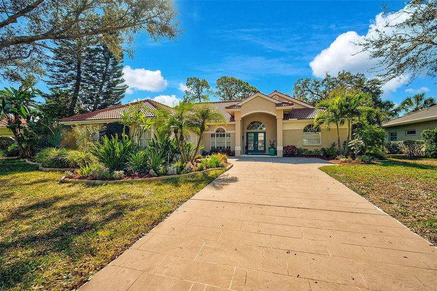 Indulge in unparalleled expansive VIEW of the TRANQUIL LAKE coupled being just steps away from the heated, COMMUNITY POOL. This verdant golf course within the maintenance-free Woodland Trails enclave of Calusa Lakes is just tucked down a quiet, tree-lined street. This nearly 1,900 sq. ft. residence radiates a sense of openness and luminosity, featuring an impeccably designed open-concept layout, three generously proportioned bedrooms and soaring vaulted ceilings. A newly installed ROOF (2022) and electrical panel (2025) provides peace of mind coupled with exquisite QUARTZ countertops in the kitchen complemented by new stainless steel appliance package (2025). The two bathrooms have been thoughtfully upgraded with new quartz surfaces, and the soaking tub provides an ideal space for relaxation.
Expansive sliding glass doors and an abundance of windows grace the rear of the property, framing uninterrupted vistas of the serene lake, the 5th hole tee box, and the lush woodlands beyond—a view that will enchant you daily. Majestic oaks and pines provide a natural canopy, offering shade and privacy from all sides, creating an idyllic retreat. The generous lanai, surrounded by meticulous landscaping, ensures complete seclusion from neighbors, while the thoughtfully designed turn-around space in the driveway eliminates the need to reverse onto the street. Elegant, modern furnishings are available for purchase, ensuring an effortless, move-in ready transition. Calusa Lakes is one of the most sought-after communities in Nokomis, ideally situated with convenient access to the Gulf of Mexico, exquisite dining, boutique shopping, cultural venues, and the newly opened Sarasota Memorial Hospital. This exceptional neighborhood is defined by its towering shade trees, picturesque lakes, well-maintained homes, a semi-private golf course and clay tennis courts. Whether you are seeking a full-time residence or a seasonal sanctuary, this distinguished property in Calusa Lakes provides the ideal setting for your Florida haven.
