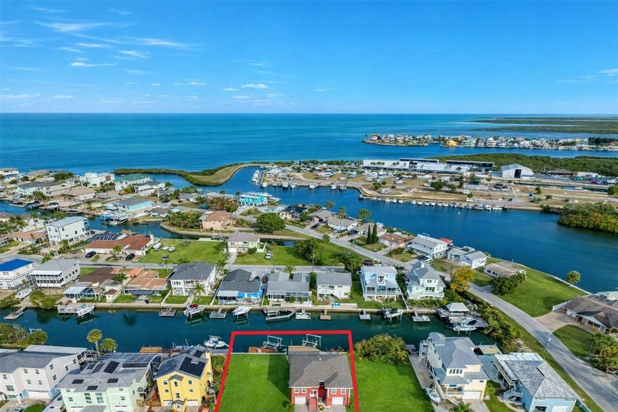 **DOUBLE LOT with 2 BOAT LIFTS ** DIRECT GULF ACCESS** Welcome to the salt life and waterfront living! This ELEVATED 3-bedroom 2-bathroom home has DIRECT GULF ACCESS and INCLUDES the vacant lot next door. Build a sparkling pool or your dream outdoor kitchen and entertaining space. Or build a home for your family or best friends. As you enter this home, you'll find an open concept with a split bedroom plan. The kitchen features a large island with seating and STAINLESS-STEEL appliances. (NEW dishwasher being installed now) Step outside on your screened in porch for morning coffee or relax watching beautiful sunsets. The primary suite is large enough for all your king size furniture along with a walk-in closet and a full bathroom. On the other side of the home, you'll find 2 bedrooms and a full bathroom. One of bedrooms also has access to the screened in porch that your guests will love. Downstairs is the 3-car garage with 15' ceilings and a workshop area. There is also an office or home gym area. Step out back to the patio for grilling and entertaining and look for dolphins and manatees. This is an EXCEPTIONAL property with 110' feet of waterfront and endless possibilities. Come live the salt life and enjoy all the Gulf life FISHING, SWIMMING AND BOATING. Hudson Beach is a small coastal town just north of Clearwater and Tampa with NO HOA! Take your Golf Cart up to small public beach and enjoy several waterfront restaurants and tiki bars. Conveniently located off Hwy 19 with shopping and hospital nearby and just 15 minutes to the expressway for easy access to Tampa and all major airports. Call me to schedule a SHOWING TODAY!