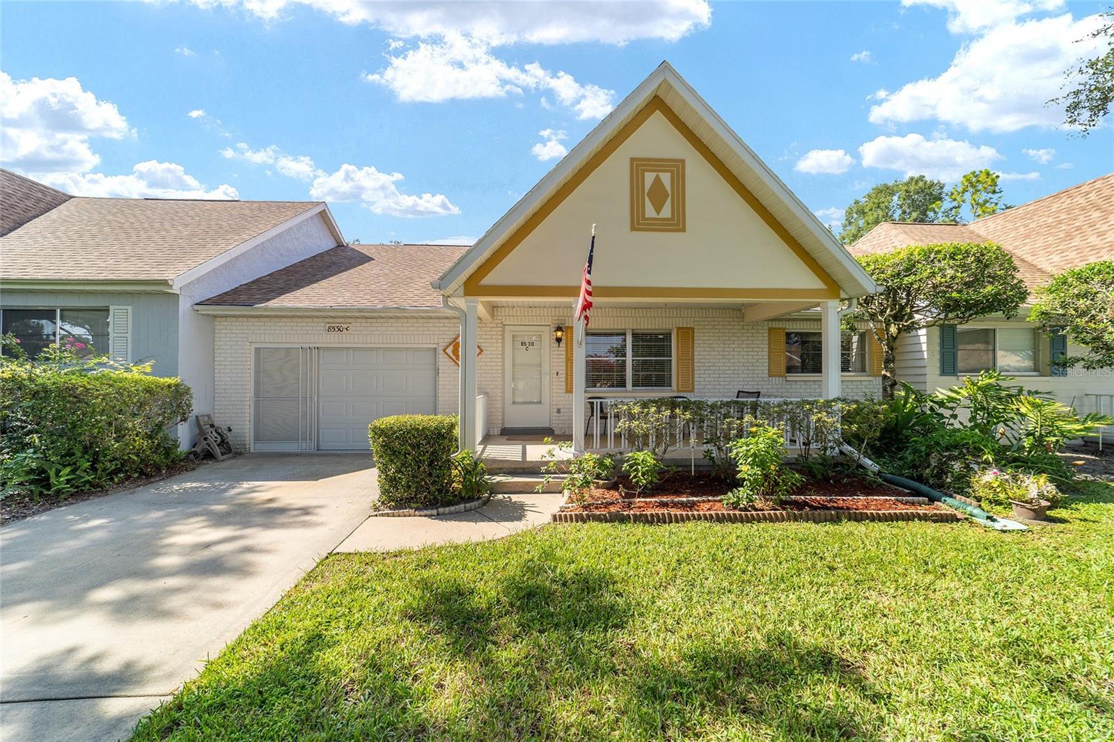Charming 2 Bedroom Villa in On Top of the World – Active 55+ Resort-Style Community
Luxury meets lifestyle in this delightful 1,375 sq ft villa nestled in On Top of the World, Ocala’s premier 55+ gated community. Designed for connection, comfort, and convenience, this home places you in the heart of resort-style living while offering personal serenity amid lush landscaping and abundant natural light. Start your day by strolling or hopping on your golf cart to explore the vibrant community amenities—where three championship golf courses, sparkling indoor and outdoor pools, state-of-the-art recreation centers, tennis, pickleball, bocce, fitness classes, arts and crafts studios, even a radio-controlled flying field await. Weekly events, live concerts, master classes, and so many social clubs keep life as social or serene as you choose. Feeling spontaneous? It’s easy to motor over to Publix or nearby shops and restaurants with your golf cart. Pull off the road and onto your private driveway—this tasteful villa is freshly landscaped and welcomes you with a charming front porch. Enter a light-filled open layout combining living and dining spaces. Adjacent, the kitchen has tons of cabinets, ample countertops, and bright and inviting! The kitchen also features a handy breakfast area and clever pass-through window leading to the back addition—the back of the home has two features.. your choice of a cool, air-conditioned sunroom or the screened porch just adjacent. The air-conditioned room is draped in windows, and the screened porch is accessible from the sunroom or through sliding doors from the master suite. This space is ideal for relaxing with morning coffee, reading the paper, or simply enjoying the gentle breeze. Additionally, this home features 2 bedrooms and two bathrooms, plenty of storage and a one car garage with built-in storage for effortless organization. All of this sits within a community that's as active as comfortable golf cart to clubs, events, shopping, or a neighbor’s home. Experience carefree living without compromise, in a home that blends thoughtful amenities, connectivity, and that relaxed, always-on-vacation charm that On Top of the World delivers.