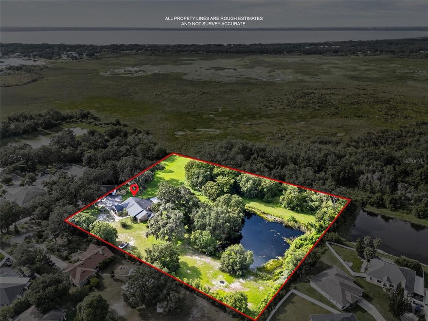 One or more photo(s) has been virtually staged. Welcome to Your No-HOA Oasis, 2 lots combined totaling almost 5 acres! OWNER FINANCING AVAILABLE for qualified buyers, making this exceptional property even more accessible! Experience nearly 5 acres of privacy and natural beauty in this stunning 4-bedroom, 3-bath pool home offering 3,352 sq. ft. of living space. The home features brand-new, large windows throughout, providing gorgeous panoramic views from room to room. Enjoy a flexible bonus room ideal for work or play, along with an oversized bedroom featuring a private entrance—perfect for guests or an in-law suite. The primary suite is a true retreat, complete with a recently updated, spa-inspired bathroom and modern finishes. Step outside to your own slice of paradise with a screened pool and hot tub, cozy fire pit area, and PRIVATE PEACEFUL POND with a fishing dock. The expansive detached garage offers incredible potential—whether used for storage, as a workshop, or even refinished into an in-law suite. It includes two garage door entrances plus a large roll-up door, providing easy access for larger equipment, vehicles, or creative projects. Surrounded by mature trees and just moments from Lake Runnymede, this No-HOA retreat offers the perfect blend of privacy, space, and Florida outdoor living—all priced at recent appraisal value.