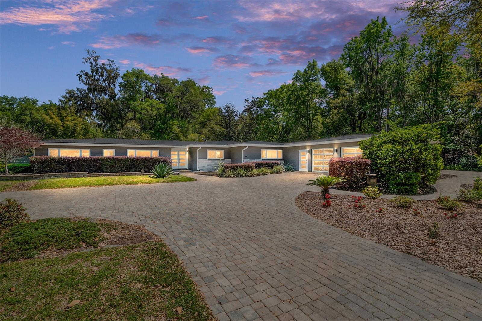 Your luxury Gator game day home just hit the market! Situated on the premier street nearest The University of Florida on 1.04 acres, this fully renovated pool home is just a short walk to "The Swamp" and boasts over 2,800 sq. ft. with 5 bedrooms, 3 baths, and the ultimate backyard oasis. Step into this sleek, modern home featuring a split floor plan and open-concept living space. The kitchen showcases custom cabinetry, a prep island, stainless steel appliances, and a large walk-in pantry. Off the kitchen, you'll find a custom wet bar area with multiple seating options overlooking the living room, which is centered by 3 TVs. Ensuring you won't miss a single play, the home is equipped with the Control4 entertainment system for whole-house sound and TV, both indoors and out, with a professional sports bar TV matrix allowing multiple feeds on all of the TVs. Off the main living space, you'll find a light filled room perfect for your favorite table games. Step into the relaxing retreat of the owner's suite, complete with a spa-like bath featuring dual vanities and a double rain shower. Double French doors lead out to a private rock garden patio featuring dual glass fire pit areas. Heading to the guest wing, which can be closed off with a pocket door, you'll find four guest bedrooms and two full baths. The largest of the guest bedrooms includes an en suite bath that leads out to the pool area. Featuring a sun shelf and waterfalls, the saltwater pool is the perfect place to unwind after the game. The backyard also boasts a fire pit area with multiple seating options, pathways, pergolas and a large covered deck offering additional entertainment options. The home features dual driveways and two, two-car garages, plus additional parking spaces to accommodate all of your family and friends for game day. Enjoy low utility bills with solar panels, high-efficiency tankless water heaters, foam insulation and an irrigation well. Whether you're looking for a place to live year-round or a seasonal getaway, this home promises unforgettable experiences and memories. Don't miss out on this incredible opportunity!