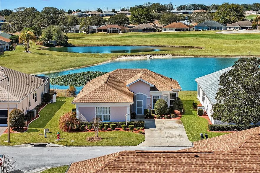 Located in the Beautiful 55+ Gated Golf Community of STONECREST, with all the amenities, adjacent to THE VILLAGES, Florida, this charming 2 Bedroom plus DEN, 2 Bath home offers the perfect blend of comfort, convenience, and carefree living with TILE Flooring throughout and exquisite LAMINATE Flooring in bedrooms. ROOF (2015). Relax on your screened LANAI overlooking the water, where you can enjoy breathtaking sunsets and watch golfers in the distance across the lake, a peaceful and picturesque setting to end each day.  This home is situated in an area where the POA MAINTAINS the grounds, allowing you to truly enjoy every day without the worry of yard maintenance. Spend your time embracing the lifestyle instead of working in the yard.  Stonecrest offers an incredible array of amenities, including four pools, one of which is an indoor Olympic-size pool, along with a spa, tennis courts, pickleball courts, softball field, bocce ball courts, and dog parks. The community is golf cart accessible to restaurants, BJ’s, banking, medical offices, shopping, and so much more, making everyday errands and outings easy and enjoyable.  There’s never a dull moment unless you want one. Isn’t it time you started enjoying retirement at an affordable price? Don’t miss your opportunity to own this magical home and experience the lifestyle you deserve.