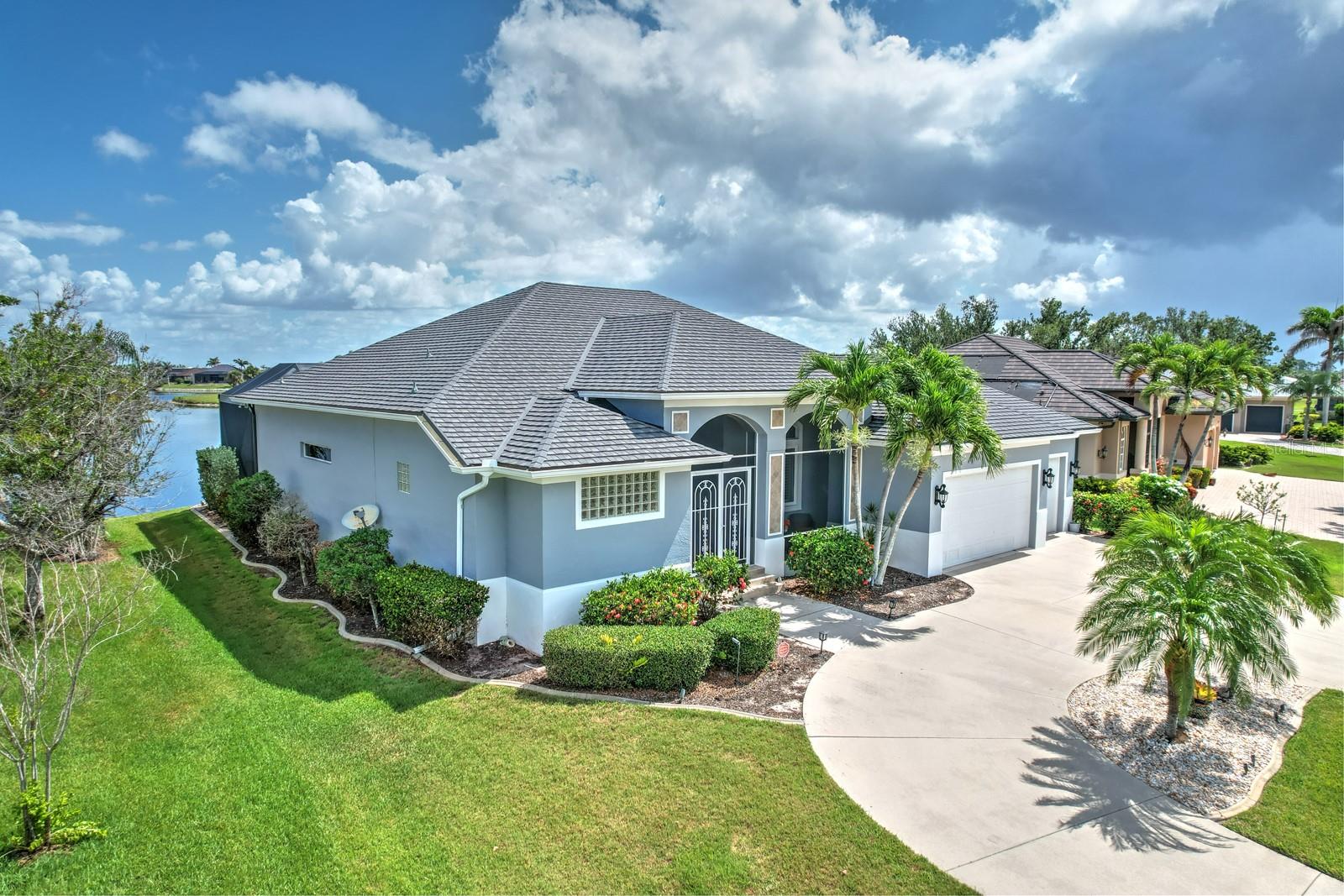 Don’t miss this rare opportunity to own a stunning custom estate home with sweeping water views from nearly every room! Located on one of the most sought-after streets in Burnt Store Lakes, this beautifully designed 3-bedroom, 2-bath home with 3-car garage, pool, and spa sits on a premium lot overlooking the community’s largest lake. Thoughtfully crafted by one of Punta Gorda’s premier builders, this residence offers wonderful curb appeal, timeless design and exceptional quality. Inside, a spacious open floorplan welcomes you with high ceilings, crown molding, 8’ interior doors, and plantation shutters throughout. The great room features lighted tray ceilings, decorative columns, and expansive disappearing sliding doors that lead to the lanai, flooding the space with natural light and lakefront views. The chef’s kitchen is an entertainer’s dream, boasting granite counters, center island for additional prep space, wide breakfast bar with pendant lighting, stainless appliances, staggered cherry hardwood cabinetry, tumbled tile backsplash, huge walk-in pantry, and a generous dining area plus a separate breakfast nook to give you all the tools for a perfect party or intimate dinner. Retreat to a luxurious primary suite with private pool access, two walk-in closets, and a spa-style bath featuring a walk-through shower and 2 separate vanities. A spacious guest wing offers two oversized bedrooms, one with pool access, the other with an extended closet for extra storage, and a shared bath with a walk-in shower. Refined finishes include a large aquarium window overlooking the pool, lighted tray ceilings in dining, great room, and primary bedroom, spacious laundry room with storage cabinetry and utility sink. Relax under a wide under cover lanai and enjoy the newly pavered pool deck, resurfaced pool and the million dollar lake view beyond. Whether relaxing in the pool and spa or entertaining guests, this backyard oasis is your personal slice of paradise. The air conditioned 3 car garage offers space galore for your cars and outdoor toys. You’ll feel secure with the new stone-coated metal roof installed in 2024, new hurricane-rated windows and an 8000 watt generator. You can look at a lot of other homes but you’ll find tremendous value right here!