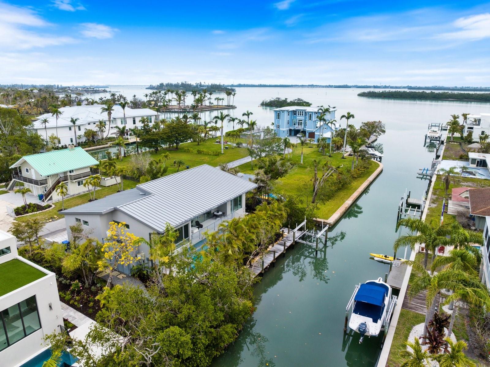 The Future of Luxury Living on Longboat Key! Discover this newly constructed coastal retreat that sets the standard for modern waterfront living. Located on the private north end of Longboat Key, this turnkey-furnished residence is a sanctuary of style & elegance. Soaring 16-foot driftwood ceilings create an atmosphere of warmth and grandeur, while large impact glass sliders connect you seamlessly between indoor and outdoor living. From the porcelain tiles, custom cabinetry, quartzite countertops in the kitchen to the Italian glass vanities in every bathroom, this home has been constructed with every detail in mind. Enjoy customizable Lutron lighting, automatic shades, built in surround sound system, and a Brinks alarm system with CCTV cameras to protect it all. Looking outdoors, a fire pit, outdoor grill, luxury pool & spa with a waterfall, newly installed dock & 10,000 lb boat lift await you. Built to withstand the elements, this flood-resistant home remains untouched by storms & was powered throughout the storms with it's own generator, offering peace of mind and unmatched durability. Experience the perfect fusion of luxury, privacy, and coastal charm—schedule your private tour today.
