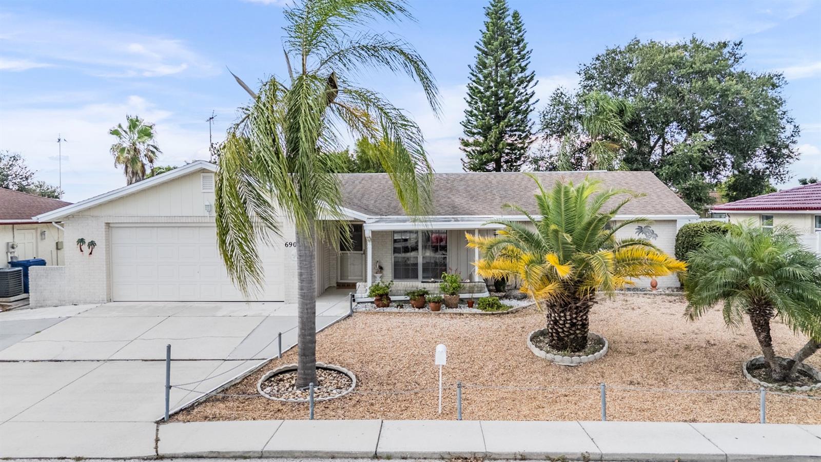 **Assumable VA Loan at 5.5%!** Save thousands in interest with this rare financing opportunity on a lovely updated, move-in-ready home packed with upgrades. This 2-bed, 2-bath, 1,528 sq. ft. property offers space, style, and versatility—ideal for families, retirees, or anyone who loves to entertain. Inside, an open-concept layout flows into a tiled Florida room, giving you flexible living space for a game room, studio, or second lounge. The chef’s kitchen features granite counters, rich wood cabinets, newer stainless appliances, and a smart range with built-in air fryer. A breakfast bar connects the kitchen to the main living area, perfect for everyday meals or hosting guests.
Need more room? A second living area can be used as a formal dining room and can easily flex to suit your lifestyle. The primary suite offers a peaceful retreat with a large closet. The Guest Bathroom has been updated and has a walk-in shower. The second Bathroom is so charming with a tub and shower combo. Enjoy Florida living with multiple outdoor spaces: a screened back porch, a sunny Florida room, and a welcoming front porch. Upgrades include a 2023 Trane high-efficiency A/C with transferable warranty ($199.00 Transfer fee). The A/C includes a 5" color touchscreen thermostat with remote access via its App. Also, the electrical panel was updated, along with the water softener was updated with energy-conscious features for low utility bills. The home also has a brand new dishwasher. Located in a no-flood zone (X), this home also boasts a spacious 2-car garage with storage, laundry, attic access, and a workbench. Main Roof 12 and the Flat Roof 3 years old. This home is Just minutes from shopping, schools, dining, parks, and major routes to Tampa Bay. **$20,000+ in recent upgrades and an assumable VA loan at 5.5%—schedule your showing today!**
