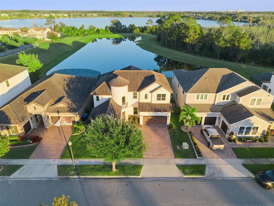 Discover refined living in this impressive 5-bedroom, 4-bathroom Spanish-style estate home, beautifully positioned on a serene waterfront lot with peaceful conservation views and nightly Disney fireworks from your own backyard. This exceptional home blends elegance, comfort, and energy efficiency throughout its thoughtfully designed layout.

Step through the grand, elegant entrance into a soaring cathedral-ceiling foyer that leads to spacious formal and casual gathering areas. The formal dining room sets the tone for entertaining, while the gourmet kitchen is a true showpiece—featuring an oversized island, dry bar, walk-in pantry, solid wood cabinets, granite countertops, elegant backsplash, and high-end stainless steel appliances. A striking stone accent wall with an electric fireplace adds warmth and style to the main living area, which opens through French doors to breathtaking water and conservation views.

The first floor includes a comfortable guest bedroom with a walk-in closet, a full guest bath with convenient pool access, and a luxurious primary suite. The primary bedroom offers a huge walk-in closet, and a spa-inspired ensuite bathroom with garden tub, expansive walk-in shower with multiple rain shower heads, and dual vanities.

Upstairs, a spacious loft with surround sound showcases elevated views of the water and conservation area—perfect for a media room or game space. On one side of the loft sits a private bedroom with its own full bath, ideal for guests or extended family. On the opposite side are two additional bedrooms connected by a Jack-and-Jill bathroom, providing comfort and privacy for everyone.

Additional highlights include a tile roof, oversized garage, paver driveway, Smart thermostat, water softener and filtration system, and energy-efficient features for year-round comfort.

Located in the highly desirable Watermark community, residents enjoy resort-style amenities including a sparkling pool, water park, cabanas, BBQ areas, playground, dog park, tennis and basketball courts, clubhouse with rooftop deck, weekly community activities, fitness center, and scenic walking trails.

All of this—just minutes from top-rated schools, dining, shopping, Orange County National Golf Course, and Disney World.

A perfect blend of elegance, comfort, and unmatched location—this waterfront estate is truly a must-see.