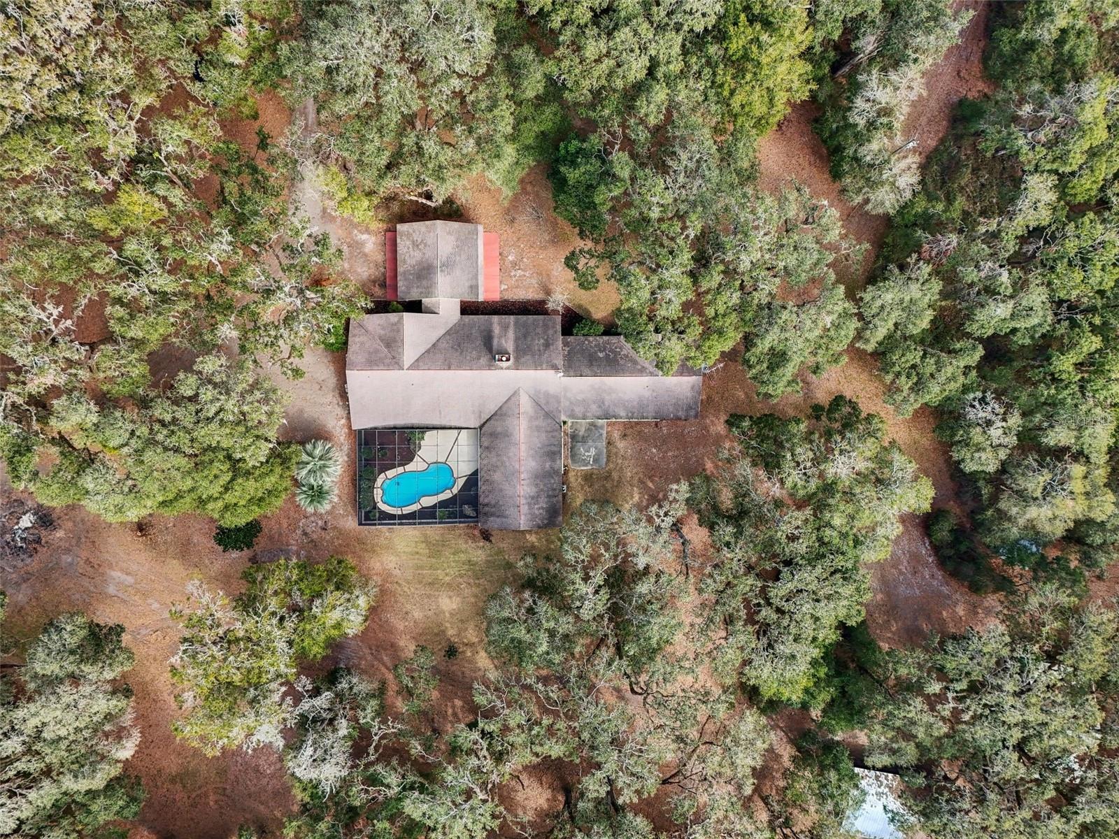 It is a rare treat to find a custom built Robert Hogan Construction home available for sale. They are passed on through generations and not often available on the open market, but 2025 is smiling on you. Here is your opportunity to secure this incredible home built by a great man, and yes in our book it checks all the boxes. When we say the bones are good, we really mean it. Built in 1991, the home could use some cosmetic upgrades but the traditional ranch style inspired home begs for you to not make it too contemporary. Farmhouse chic would be perfect here! Situated on a beautiful 17.5 acres. Pasture up front on the north side for your farm animal friends, and homesteading dreams, and the privacy of living amongst the trees on the south side of the property. All of the mechanical components are either new or in great working order. The seller says the roof was replaced in 2013 as per the insurance company. HVACS replaced in 2024. Water heaters were replaced in 2024. Brand new water softener and iron filtration system in 2024. Recent 4 point inspection completed November 2024. Both septic tanks were pumped and one new drain field 2024. The absolutely “oh my moment” that is the patio and pool area was recently refreshed with new landscaping, new pool coating, and new pool tile. A true split plan, which back in 1991 was not common, this house is huge but yet somehow cozy. This floor plan is one of the best we have seen. The entrance is stunning with a double door entry, traditional tile landing that is in phenomenal condition and vaulted, original, tongue and groove ceilings that still shine like new, complimented by a gorgeous brick, wood burning fireplace, and brick built-ins. We have never seen a wall of sliders on a home built in 1991, but this home has not just one but two, double sliders with a remarkable view of the patio. The kitchen will “wow” you too. It’s big. Cabinets and counter space for days. Center island with more cabinets. Brand new Samsung appliances December 2024. A large pass through window into the game room, and a walk-in pantry to store the extra snacks. The game/family room is over 700 sqft. Game night, movie night, holiday celebrations, you name it this room was built for it. Off of the game room is another “mini” house or in-law suite. It features its own entrance, living room, bedroom, bathroom, and a room that could serve as a kitchenette….all under the same roof. Technically a 4 bedroom 4 bathroom home OR a 3 bedroom 3 bathroom home with a 1 bedroom 1 bathroom guest suite. Brand new Maytag washer and dryer in the laundry room/craft room. There are plenty of closets and lots of storage space but if you need more, there is not one barn on-site but two. It is a true pleasure to get to showcase this home for sale and we cannot wait to show it to you. If you think the pictures look great just wait till you see it in person. Conveniently located on the north side of Bushnell with easy access to The Villages, the Florida Turnpike, and Interstate 75. Only 1 hour from Orlando International Airport, Walt Disney World, Tampa International Airport, the World and Equestrian Center. Very easy to show, but by appointment only. Please do not go onsite without an appointment and your Realtor. You cannot see the house from the road and the gate is locked. We don’t want you to waste a trip. Don’t take our word for it, we are most definitely biased. We think it’s an amazing home, come see for yourself.