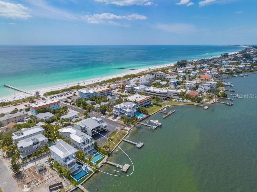 VIEWS, VIEWS AND MORE VIEWS!!! Positioned directly on the sparkling waters of the bay in Bradenton Beach on Anna Maria Island, this extraordinary coastal estate offers over 4,000 square feet of luxury waterfront living. With five spacious bedrooms and five and a half baths, this home captures the essence of island elegance while delivering high-end comfort and resort-style amenities. It is truly a rare opportunity to own one of the island’s premier bayfront properties, complete with sweeping water views, a private dock, and incredible rooftop panoramas of both the Gulf of Mexico and the bay.This home makes a stunning impression from the moment you arrive. The tropical landscaping and striking architecture immediately convey a sense of vacation-ready serenity. Inside, the open-concept design is beautifully finished with coastal accents and abundant natural light that floods in from floor-to-ceiling glass. The expansive main living space seamlessly flows from a gourmet kitchen outfitted with stunning counters and custom cabinetry to a water-view dining area and elegant lounge, all opening out to deep covered balconies. Each bedroom is thoughtfully designed with comfort and privacy in mind, many with their own ensuite baths and outdoor access. The owner’s suite is a serene waterfront haven with its own balcony and a spa-style bathroom featuring dual vanities, a soaking tub, and a walk-in shower. Every detail of this home is designed to highlight the stunning surroundings and to provide maximum comfort for everyday living or short-term vacation stays. Step outside to a private paradise that feels like your own resort. A sun shelf and water slide pour into the sparkling bayfront pool, while the adjoining spa is perfect for soaking under the stars. The lush lawn, poolside lounge areas, and waterfront dock provide endless opportunities for relaxing or entertaining. An outdoor spiral staircase leads to a rooftop balcony with unobstructed panoramic views stretching from the Gulf to the bay—one of the best sunset spots on the island.



Located just a short stroll or golf cart ride from the beach, shops, and restaurants of Anna Maria Island, this property offers the best of both waterfront tranquility and island activity. It also operates as a successful vacation rental, offering excellent income potential for investors seeking a blend of luxury and performance. Whether you’re watching dolphins swim past the dock, enjoying rooftop cocktails at sunset, or taking a dip in the pool with the bay as your backdrop, this home delivers the ultimate in coastal lifestyle.