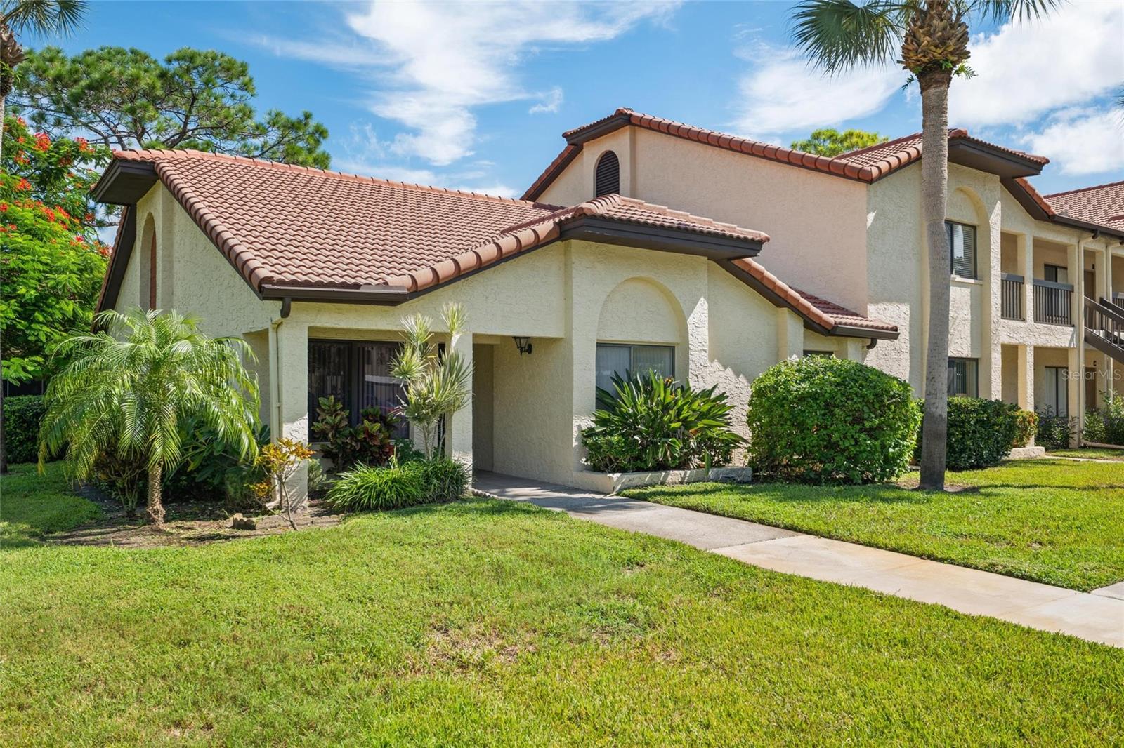 Quiet 3 BR, 2 Bath Condo Home just off East Lake Road in the beautifully well-maintained El Pasado Condominiums in Palm Harbor! Covered parking for residents and lots of visitor parking for guests. This is a corner one-story unit located near enough to the community pool for convenience, but far enough to enjoy peace and quiet. The open Great Room concept, with its vaulted ceilings, provides a sense of warmth and shared space. The upgraded kitchen and breakfast nook, featuring beautiful cabinetry, granite countertops, and matching appliances, is spectacular. Engineered wood flooring enhances the beauty of the primary living area (kitchen, breakfast nook, dining area, and living room). The enclosed porch serves as a bonus room just off the living room, and opens onto a lovely backyard. This condo has everything you need, including a location that's hard to beat! The owner is moving north and may consider selling some of the furnishings if a potential buyer is interested.