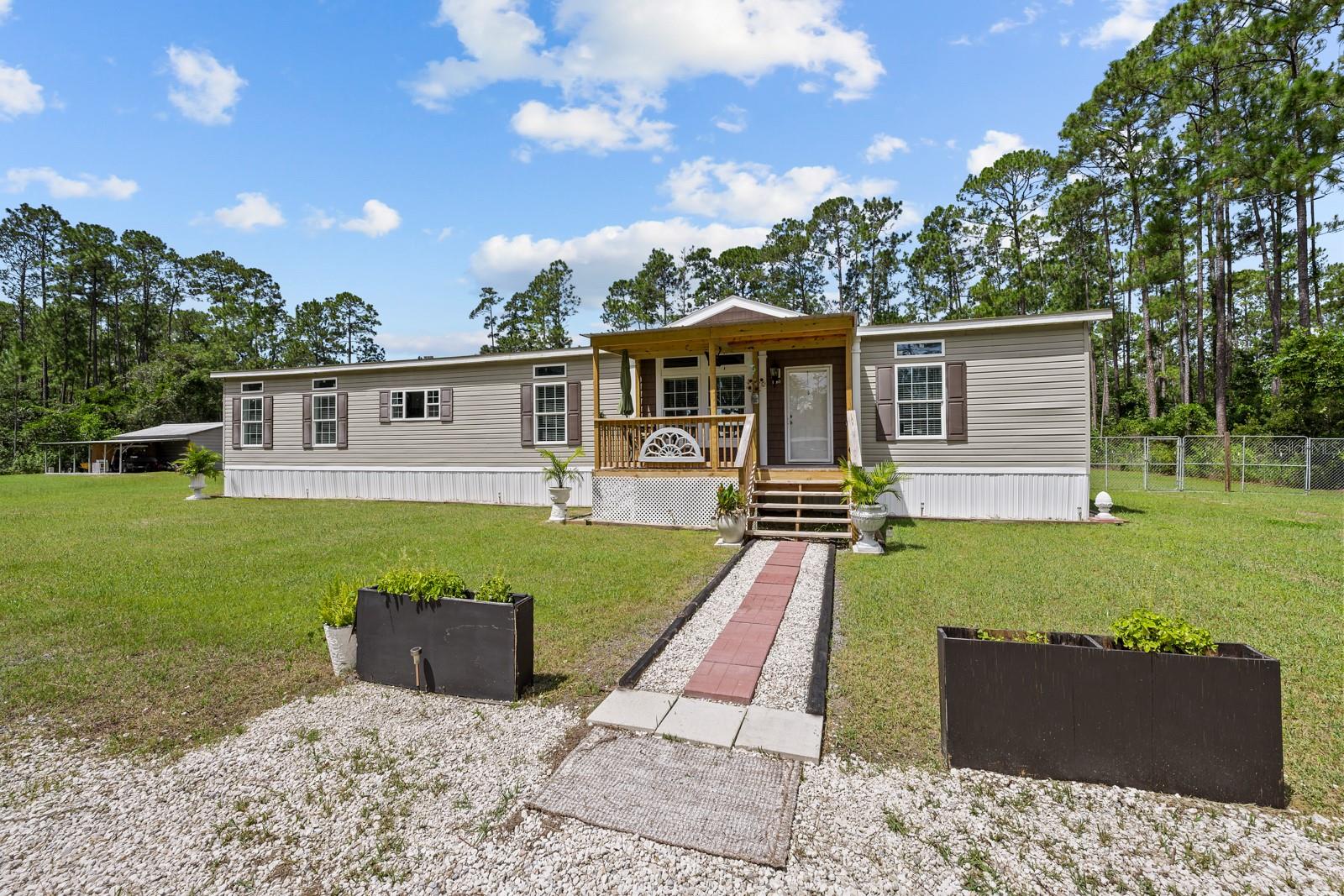 Bring the Family to this private, gated retreat, which sits on 2 acres of fenced picturesque property, offering a perfect blend of comfort, style and space and conveniently located just a short drive from shopping, medical facilities, the beach and airport. This move in ready home combines modern conveniences with the beauty and space of rural living and is located in flood zone X (no flood insurance required). Step inside to find a bright, open floor plan with numerous upgrades, including flooring, a beautifully upgraded kitchen featuring custom cabinetry, custom hood, backsplash, island and a farmhouse sink. The cozy family room is located right off the kitchen and features a fireplace for Family and Friends to gather around on cool nights. The oversized master suite features a large bathroom with a tub overlooking the tranquil backyard. The laundry room is oversized with storage cabinets and a sink. The three additional bedrooms provide plenty of space for family and guests. Step outside to enjoy serene country living, wide open grassy spaces with a conditioned 12 X 8 shed plus a 12 X 10 concrete slab that can be used in any way you envision. Also on the property is a 25 X 18 garage with a 12 X 25 overhand and a 25 X 30 slab. While outside, you will discover a Fairy Garden, lovingly designed with a running creek and a path with trees and a hammock and seating, providing an ideal sanctuary for meditation, Children's adventures and outdoor entertaining. This home was built in 2018 and was a Model home, featuring 9 foot ceilings, crown molding, and many custom touches. New A/C, septic and water filtration, hurricane windows, and generator hookup. Additionally, the Sellers are leaving the Electric Motor for the double gate, which has to be installed by Buyer. This home is located in Bunnell, in Flagler County, offering a relaxed lifestyle where spacious living and natural beauty combine to create an exceptional residential opportunity. Orlando theme parks are an hour and a half away and so is Orlando International airport. Jacksonville is an hour away. St. Augustine, the Nations's oldest City is half an hour away and so is Daytona Beach, home of Daytona International Speedway and Bike Week.
