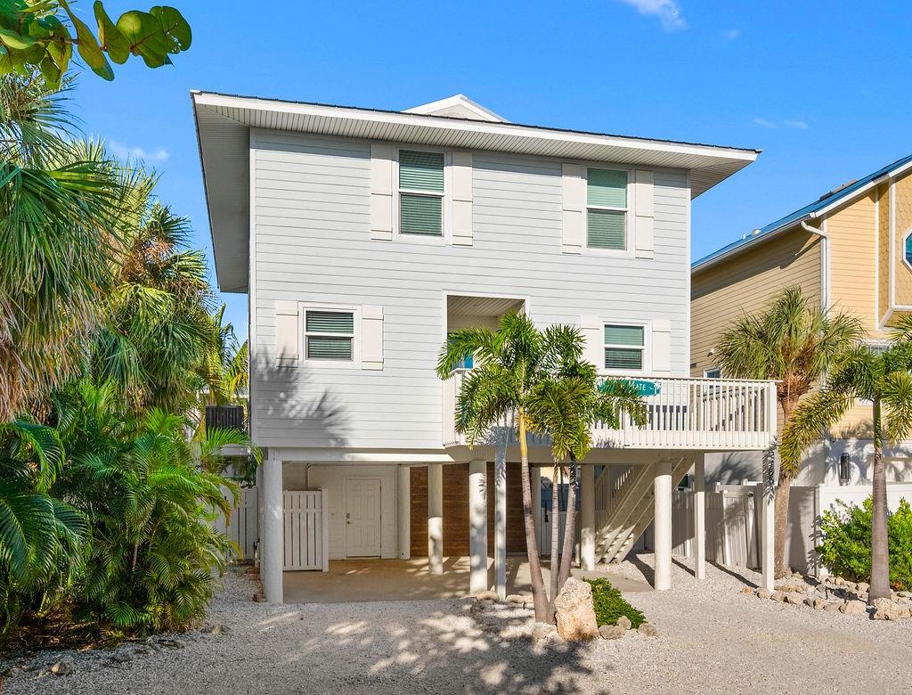 OHHHH THE UPDATES!!  BRAND NEW KITCHEN and flooring...and updates galore!  There is so to enjoy about this great investment home!  This is the perfect beach haven, just a hop, skip & a jump to the Gulf beach!  Just steps to Bean Point, this elevated 3 bed/2.5 bath pool home is a great income property! Updated with beautiful coastal style, this home is designed for relaxing.  Start the day sipping coffee on your screened porch or enjoy the space around your open dining table!  Stretch out in the family room where the coastal comfort welcomes you with shiplap walls, large updated windows, new lighting, fresh paint and furnishings.  Upstairs you will find your large bedroom with its private porch, walk in closet, updated en suite and peeks of the Gulf!  Both guest rooms also enjoy an updated (2024) bathroom and the gorgeous coastal décor!  Whether you're lounging at the poolside bar, relishing the breeze on the screened porches, relishing the comfort of your cozy bed, or using your back gate to pop over to the sugar sand beach, you will love the island life from every spot of this updated home!  From all the UPDATED appliances, the metal roof, the luxury vinyl plank flooring, the NEW doors & door frames, the NEW paint (inside & out), the NEW lighting and the NEW fans, to all the UPDATED décor - this beach house is picture perfect! And outside you will relish the added landscaping and palm trees, lighted stair way, privacy wall, covered bar and your heated pool and spa!  Enjoy a cocktail and the game while floating in the pool, and easy access to your beach toy storage space!  Inside and out this island home welcomes relaxation and enjoyment! AND you will REALLY enjoy the short term rental income!  It’s time for your island life to begin…