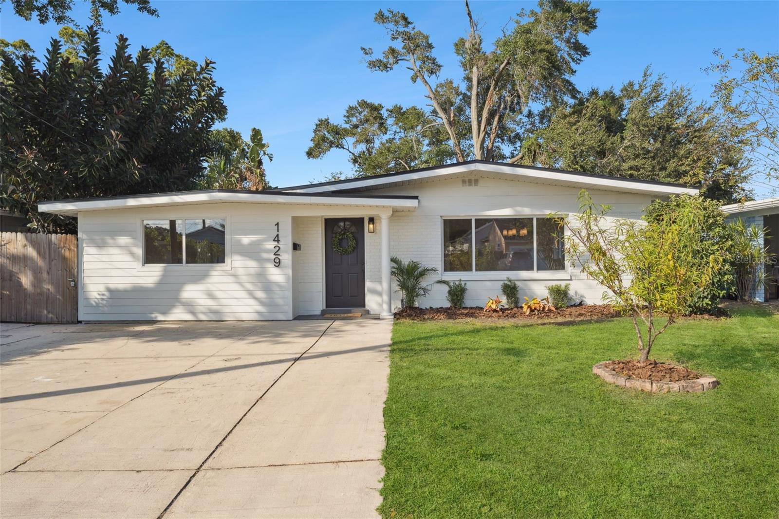 One or more photo(s) has been virtually staged. Completely remodeled 4-bedroom home in the heart of College Park!
This mid-century modern gem has been fully updated from top to bottom, featuring a new permitted roof, new HVAC, updated plumbing and electrical, new energy-efficient water heater, stainless steel appliances, soft-close cabinets, a large kitchen island, fresh landscaping, and more. Every detail has been thoughtfully designed for comfort, efficiency, and style.
Step inside to discover an open-concept layout with luxury vinyl plank flooring, fresh interior and exterior paint, and designer lighting throughout. The chef’s kitchen boasts quartz countertops, custom soft-close cabinetry, floating wood shelves, stainless steel appliances, and a large island perfect for entertaining.
The private owner’s suite offers a spa-inspired bathroom with an extended tiled frameless glass shower and walk-in closet. Two additional bedrooms share a beautifully updated full bath, while the fourth room serves perfectly as an office, studio, play room, or guest suite.
Enjoy outdoor living on the rear patio, complete with a cozy firepit, and a fully fenced backyard ideal for relaxing or hosting gatherings.
Situated just minutes from Edgewater Drive’s shops and dining, Dubsdread Golf Course, Lake Ivanhoe, and Downtown Orlando, this home perfectly blends modern luxury with classic College Park charm. Located only a few houses down from the light-use rail corridor along N Orange Blossom Trail, the nearby transfer station experiences minimal activity, maintaining the peaceful neighborhood atmosphere that makes College Park so desirable.