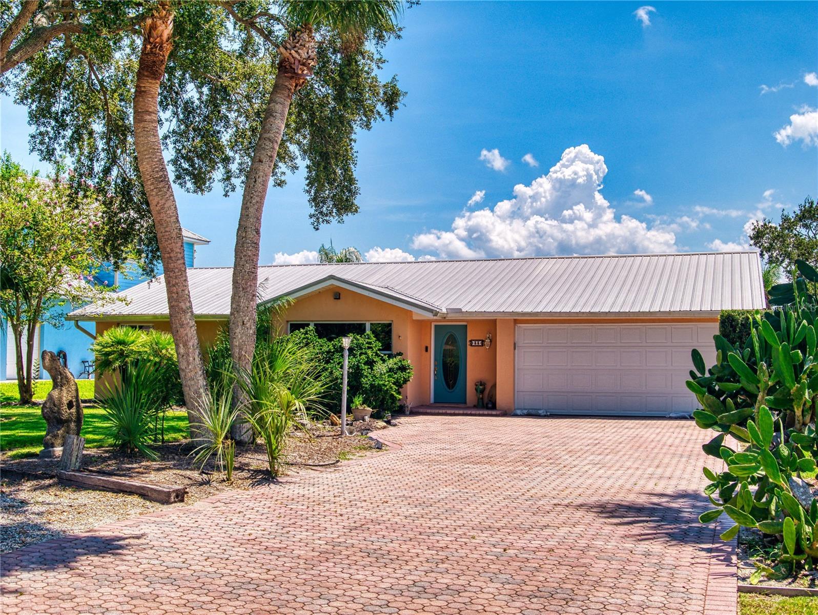 Discover this mid-century contemporary canal-front home with a saltwater pool, set on a large 75x200 lot, perfectly tucked away in a secluded riverfront community. This 4-bedroom, 3-bath residence offers a spacious, light-filled open floor plan where views of the pool, lush tropical landscaping, and Hunters Creek Canal greet you from the front entry. The living room with a cozy wood-burning fireplace flows into the dining room, expansive family room, and a large kitchen designed for entertaining family and friends. Sliding glass doors open to a covered patio overlooking the sparkling pool, private boat dock with lift, and canal that leads directly to the Intracoastal Waterway and the Atlantic Inlet. This home is ideal for a perfect family home with separate spaces for everyone. Imagine the parties and memories made in this home, designed for both comfort and to enjoy waterfront living. Additional Features Include: Interior Safe Room, Bonus Office Room, Seawall, Private Dock with Lift, Water & Electric. 3 Separate A/C Units, 2023. Metal Roof 2010, a Detached Tool Workshop. Forth bedroom not pictured. A rare opportunity to live in a private and peaceful and natural setting!
