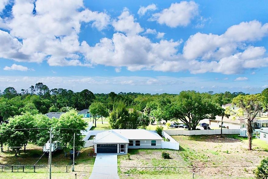 This rare property sits on 3 LOTS totaling .68 acres, offering space, privacy, and endless possibilities! This 3-bedroom, 2-bathroom home with a 2-car garage features a bright open floor plan with vaulted ceilings and a desirable split bedroom layout.  
The gorgeous REMODELED Kitchen is the heart of the home with updated appliances, soft-close cabinets and drawers, beautiful countertops, and a breakfast bar, perfect for entertaining. French impact doors lead to a large lanai, creating the perfect indoor-outdoor living space.
Recent upgrades include NEW porcelain wood-grain floors throughout the entire home, updated windows, interior doors, trim, ceiling fans, and newer toilets. The home also features a whole-house Reverse Osmosis system for high-quality water and a NEWER METAL ROOF for long-term durability. NEW Exterior Paint!! Step outside to enjoy the spacious yard with a newer 6-foot privacy fence in the immediate backyard and brick pavers to the right of the lanai, ideal for a fire pit or BBQ area. The two additional side lots provide incredible flexibility for hobbies, extra space, or future possibilities, with one side lot already featuring a 4-foot chain-link fence. A storage shed offers additional convenience. High-End Chicken Coop! 50 amp service for RV hookup!This beautiful, move-in-ready home with rare acreage and multiple lots is hard to find. Enjoy privacy, natural light, and room to grow all in one exceptional property!