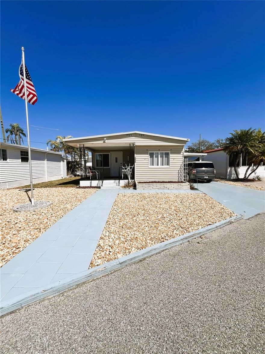 Situated on a desirable lot and a half near the center of park activities, this inviting 3-bedroom, 1½-bath home offers extra outdoor space along with comfortable living in the heart of Trailer Estates. The spacious primary bedroom easily accommodates a king-size bed, and the furnished interior makes this a move-in-ready option for seasonal or full-time living.

Outdoor features include a large carport and a versatile double shed currently used as a laundry area and workroom, providing excellent storage and functional space. A welcoming front porch offers the perfect place to relax and catch the coastal breezes while enjoying the vibrant community atmosphere.

Located in Trailer Estates, a Special Park and Recreation District governed under Chapter 418, Florida Statutes, residents own their land—no lot rent, CDD, or HOA fees. The annual park tax covers cable, high-speed internet, trash pickup, fire and rescue services, and access to outstanding amenities including a marina with rentable boat slips, private beach, pool, hot tub, fitness center, shuffleboard, bocce ball, pickleball, woodshop, and nearly 60 active clubs and social events. Experience one of Sarasota Bay’s most vibrant and welcoming 55+ communities.