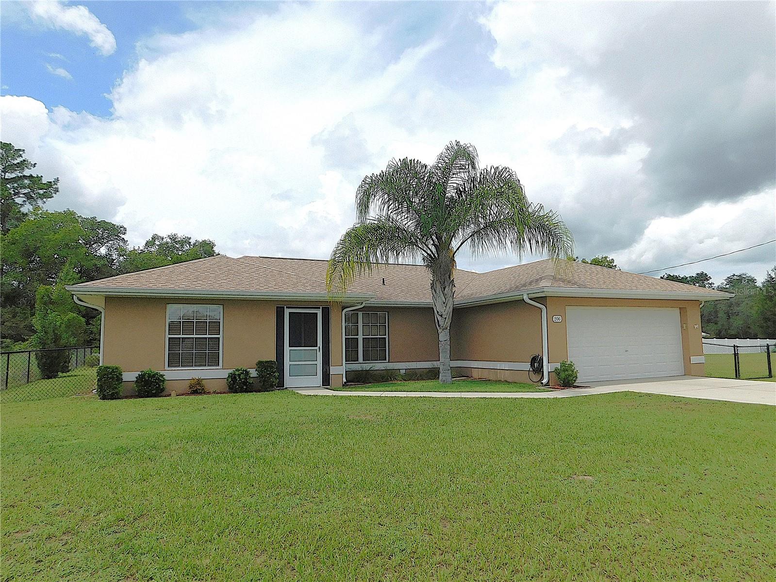 MOVE-IN READY 3BR/2BA/2GA HOME ON .24 ACRE LOT... WITH EXTRA .47 ACRE CLEARED LOT!! What a fantastic opportunity to add another home for family or a dream workshop/garage for storage... Newer roof! Newer HVAC! No Carpet! Open floor plan! Completely Fenced! This home has been meticulously cared for and features screened front porch entry, great room with vaulted ceilings & sliders to a designed back patio, great kitchen layout w/updated appliances, pantry closet, eat-at bar & dining area, primary suite w/walk-in closet & BA w/designer tile shower, 2 guest bedrooms w/double closets, guest bath w/tub combo, inside laundry room w/washer, dryer & storage cabinets.. Double garage with auto opener & long driveway.. Beautiful backyard is completely fenced with large storage shed, matching covered well pump and cleared with palm trees.. This property consists of 2 parcels with one being a cleared .47-acre lot with double gates for whatever your heart desires (house, garage, pool).. Neutral finishes throughout the home, upgraded ceiling fans in every room, upgraded window coverings, sliding doors with blind inserts, whole-house gutters/downspouts.. Close to shopping, banking & schools.. THIS IS THE ONE!