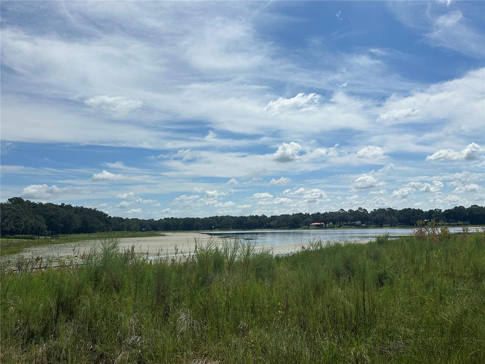 Discover a rare opportunity in Rainbow Lakes Estates: a spacious wooded 1.31-acre lakefront parcel at 2208 SW Shorewood Drive. Framed by the serene shores of Lake Bonable and Tiger Lake, with beautiful water frontage on the lake, this wooded haven offers panoramic views and enchanting privacy.
Perfectly positioned in a friendly, no-HOA community with no construction time limits (excluding mobile homes), the property includes access to a community boat ramp, docks, and recreational facilities such as a clubhouse, fitness center, tennis, and basketball courts. Outdoor enthusiasts will love the endless options for hiking, biking, paddleboarding, kayaking, and boating right at their doorstep. Just minutes from downtown Dunnellon, residents enjoy proximity to charming shops, eateries, and outdoor recreation areas including Rainbow Springs State Park, the World Equestrian Center, Ocala, Gainesville, and the Gulf Coast.
The lot features beautiful mature trees and presents an exceptional canvas for building a dream home, vacation retreat, or Airbnb rental. Rare waterfront acreage with excellent upside—schedule your visit today and envision lakeside living at its best!
? Note: Parcel has been recently split with the county and can be sold as a whole (1.31 acres) or individually between the two newly created parcels (.66 acres & .63 acres). Please reference MLS #TB8423292 & MLS #TB8423293.