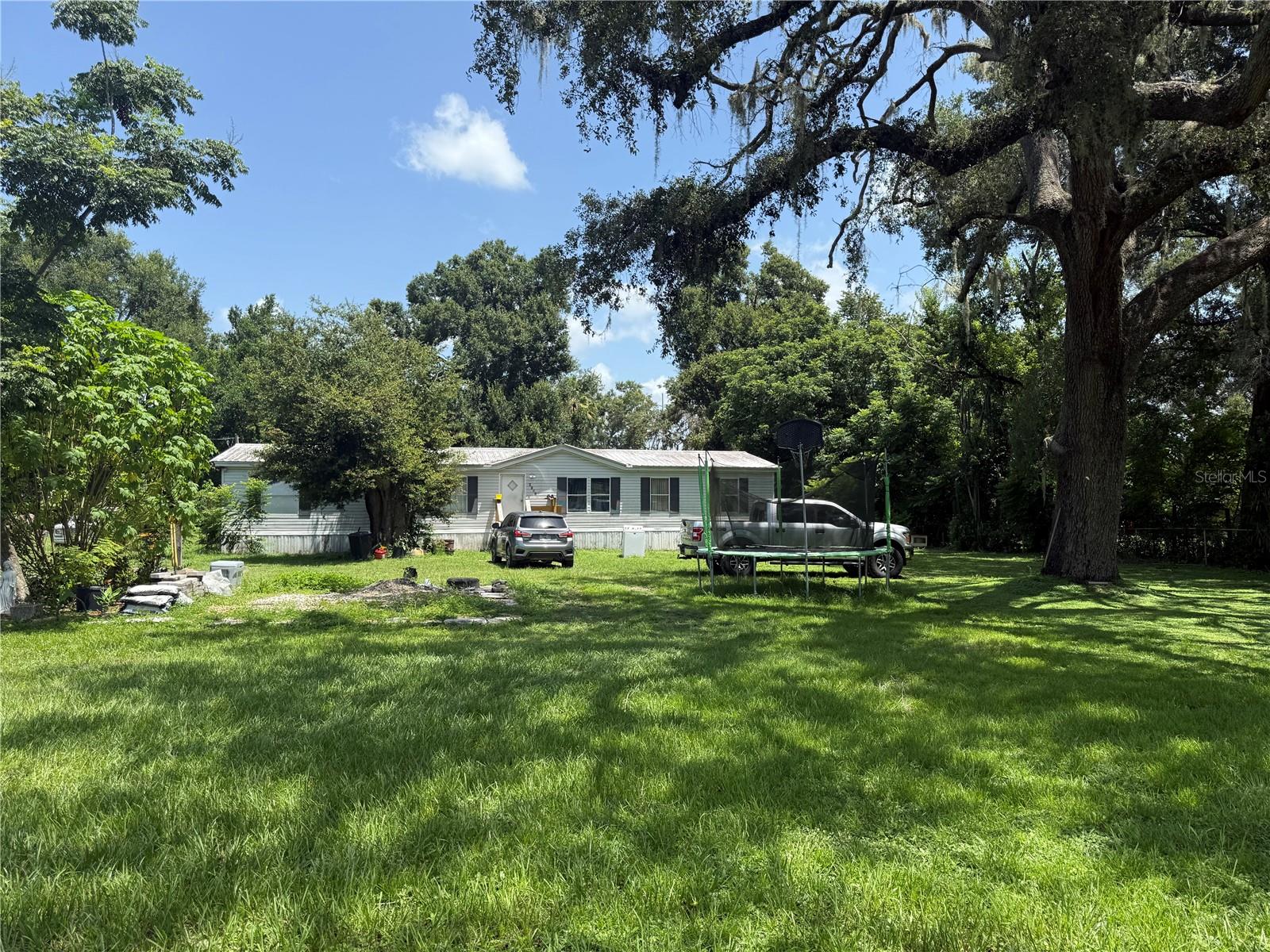 Country Charm Meets Spacious Comfort in Dade City
Nestled on 1.05 acres just outside downtown Dade City, this well-appointed manufactured home features 4 bedrooms and 2 bathrooms, offering the perfect combination of rural tranquility and natural living. Enjoy the privacy and freedom of your own land with no HOA restrictions.
Outdoors, take advantage of the expansive acreage. Whether you envision a garden, recreation space, or parking for recreational or business vehicles this property supports all your Florida-living goals and needs.
Set in Dade City, FL, known for its historic downtown, seasonal festivals (Kumquat Festival, Bug Jam), and easy access to Tampa and I-75, the location provides both a peaceful retreat and convenience within reach.
New vinyl floors in most of the house. Well pum was replaced March 2025
Newer AC and water heater were replaced beginning of 2023.